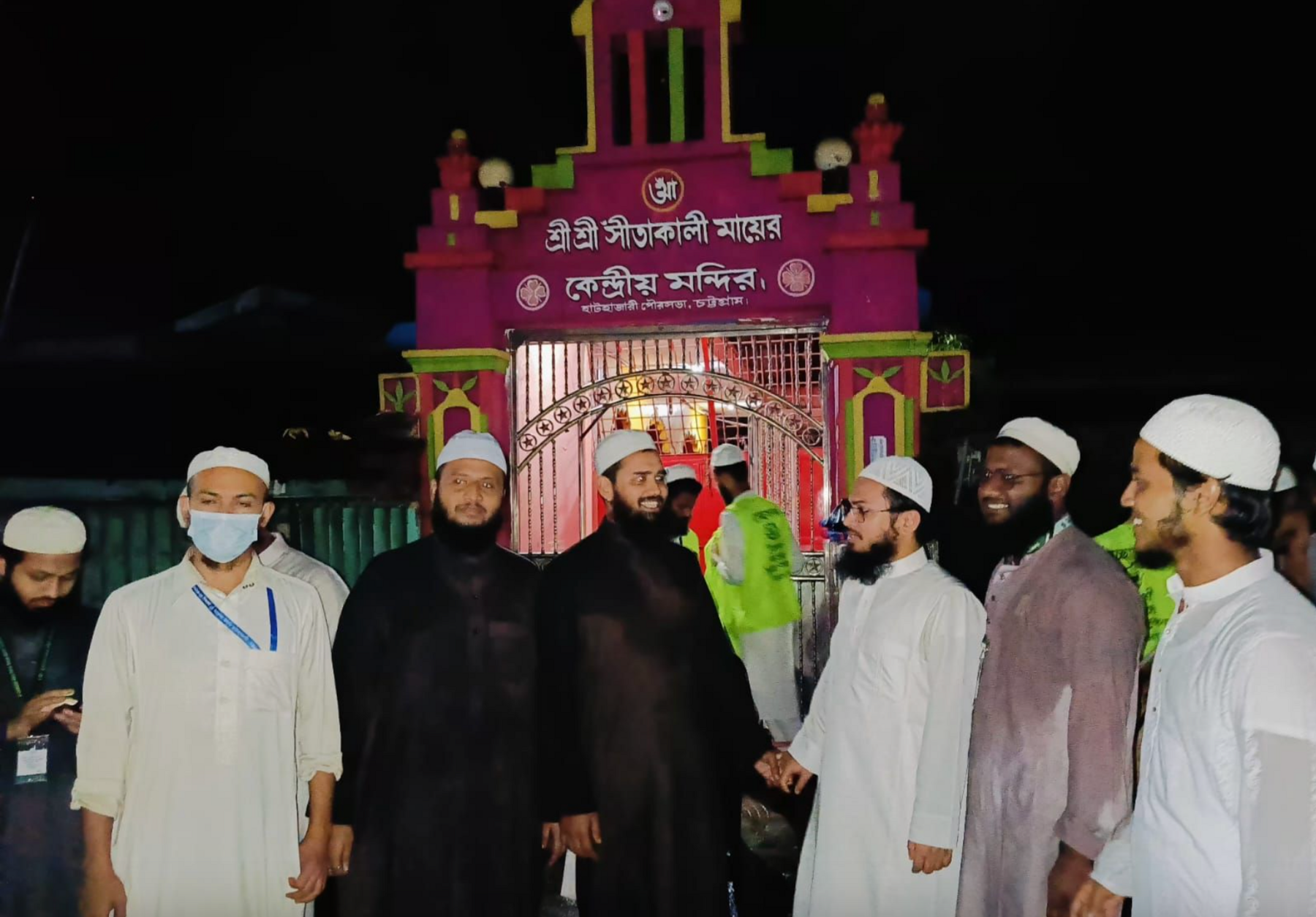 A group of muslim men stand outside a local Hindu Temple. 