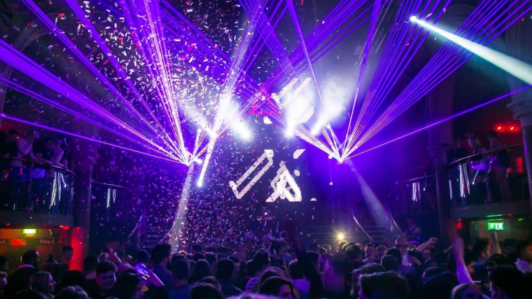 purple strobe lights in old church building with people dancing