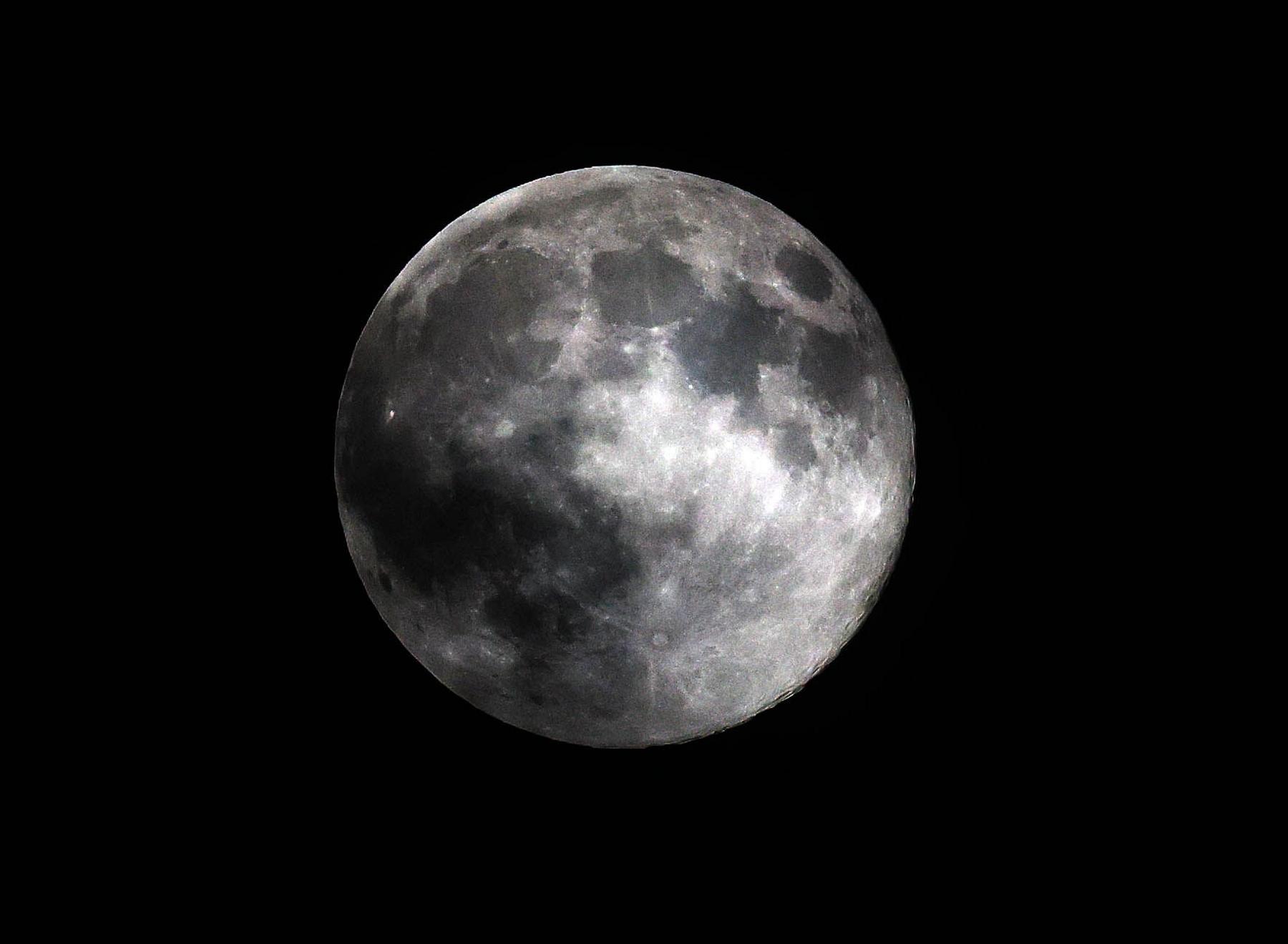 A large round grey Moon is pictured against a dark starless night sky, with crater and contour detail visible on the Moon, in London on Wednesday.