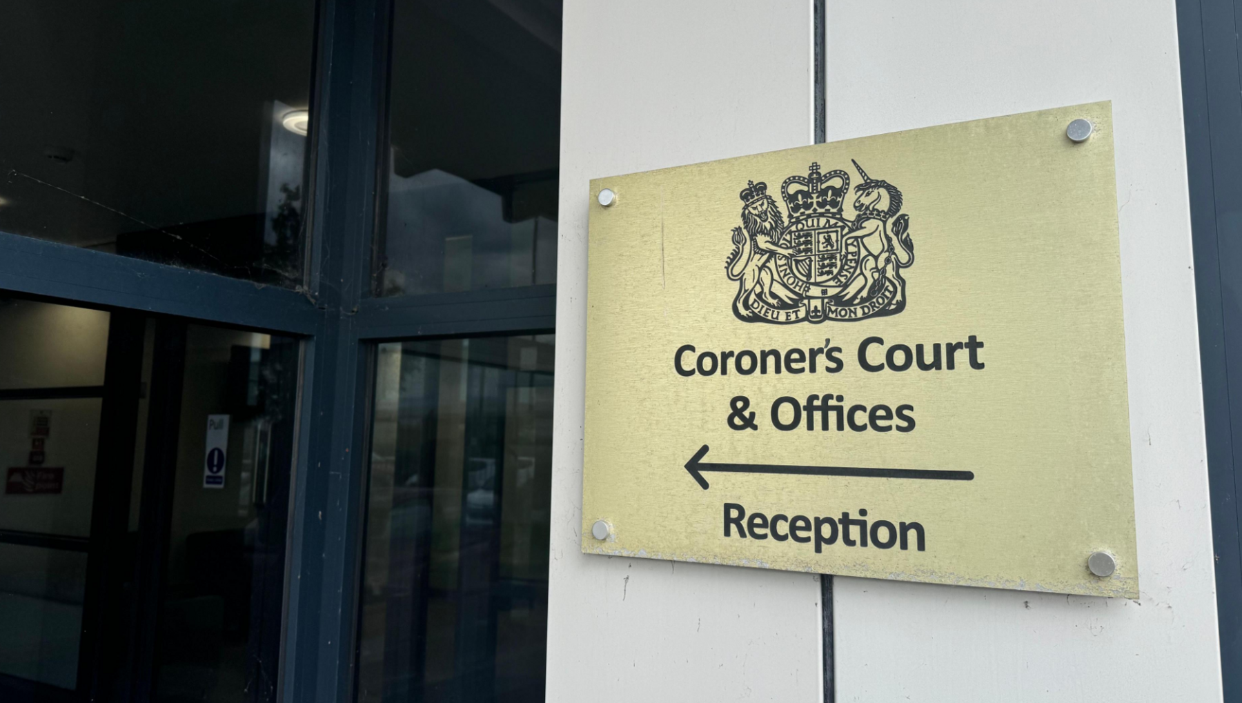 A close-up of a gold plaque which reads "Coroner's Court & Offices" at the entrance to the Beacon House building. 