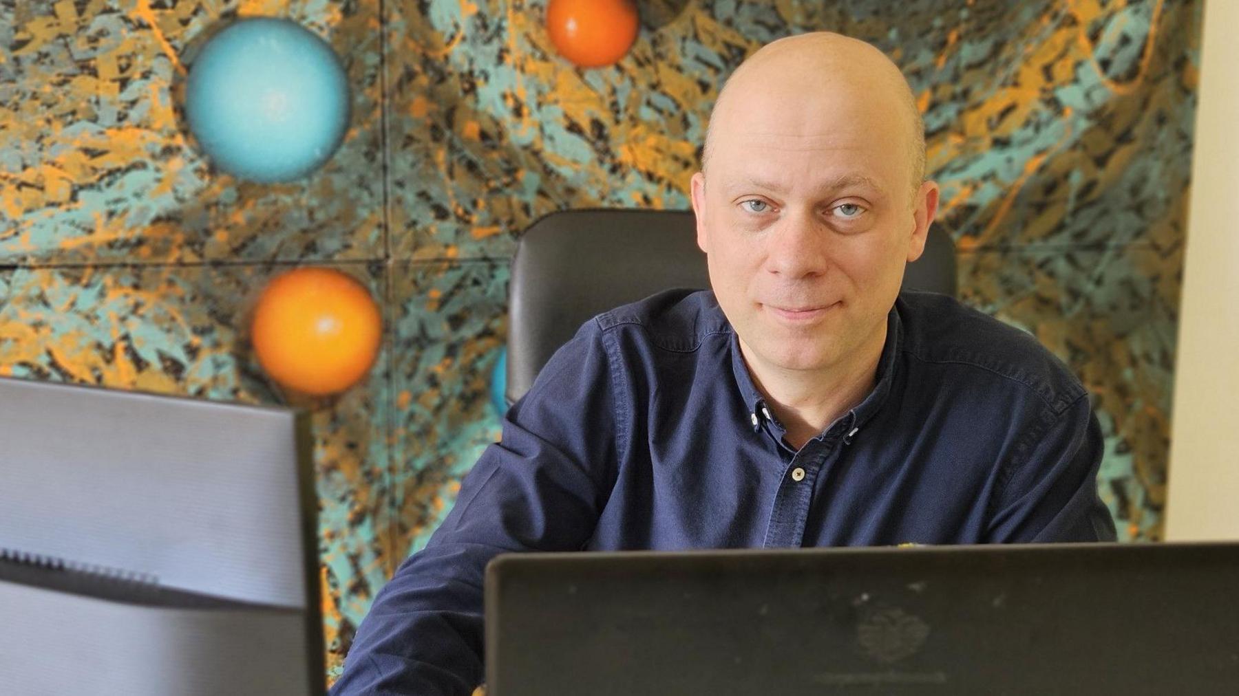 Dutch entrepreneur Luc Vocks looks at the camera while sat at his desk