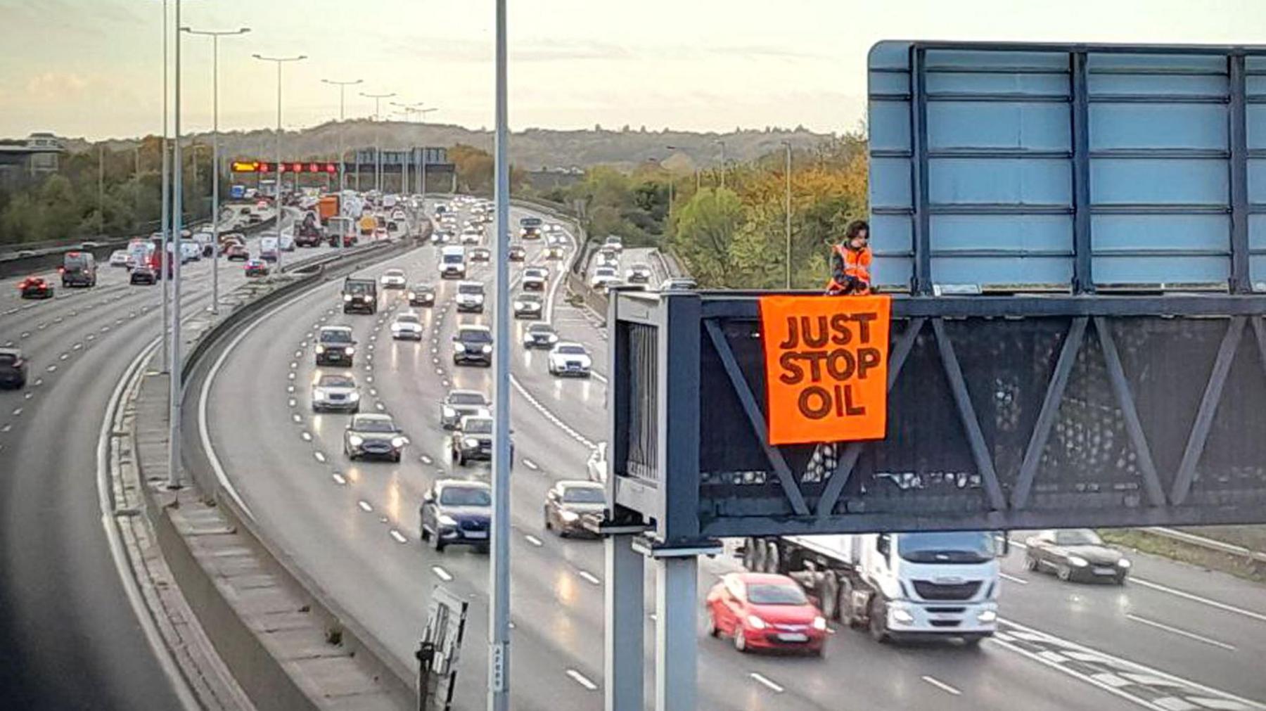 A protestor on a gantry above the M25 