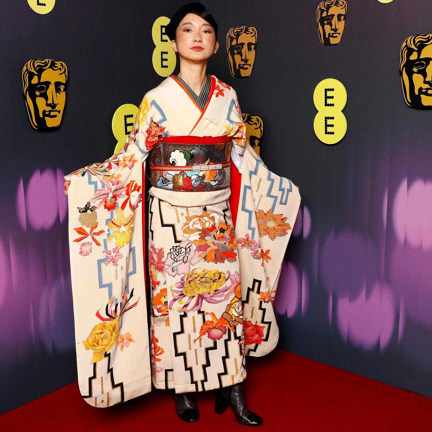 Shiori in a white kimono with orange, yellow and black detail