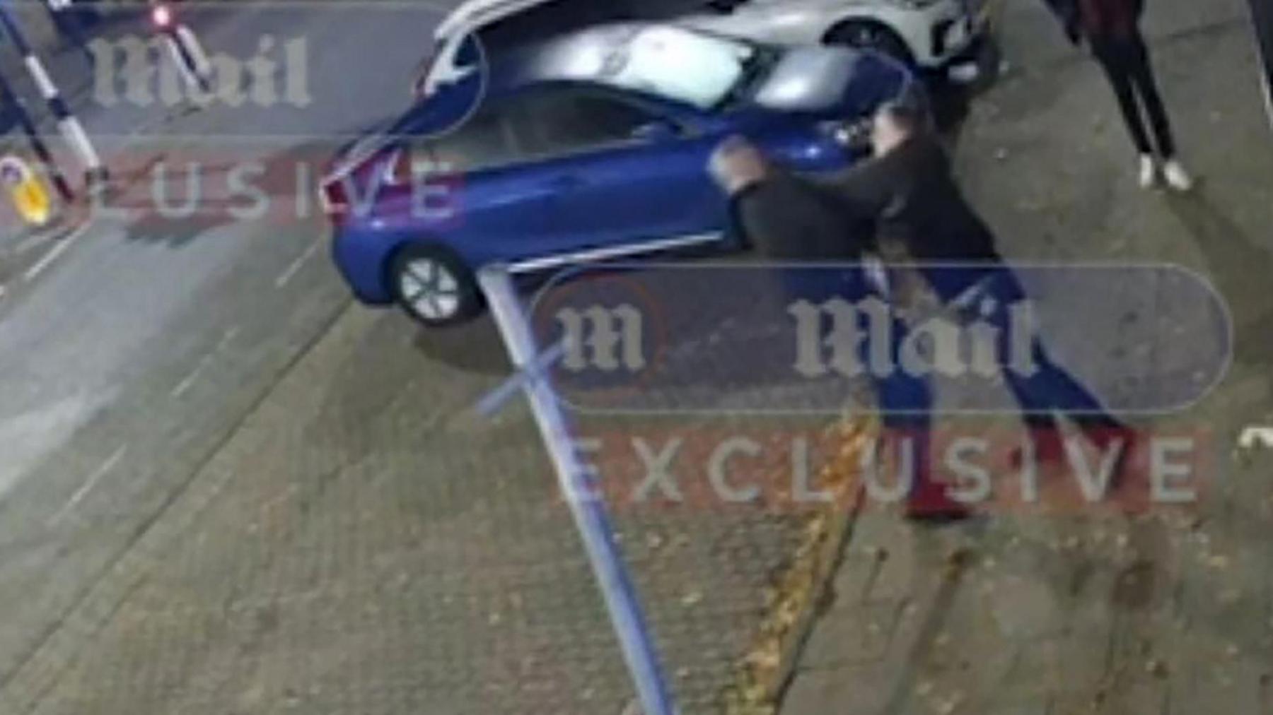 An image from a CCTV video shows one man punching another in the street