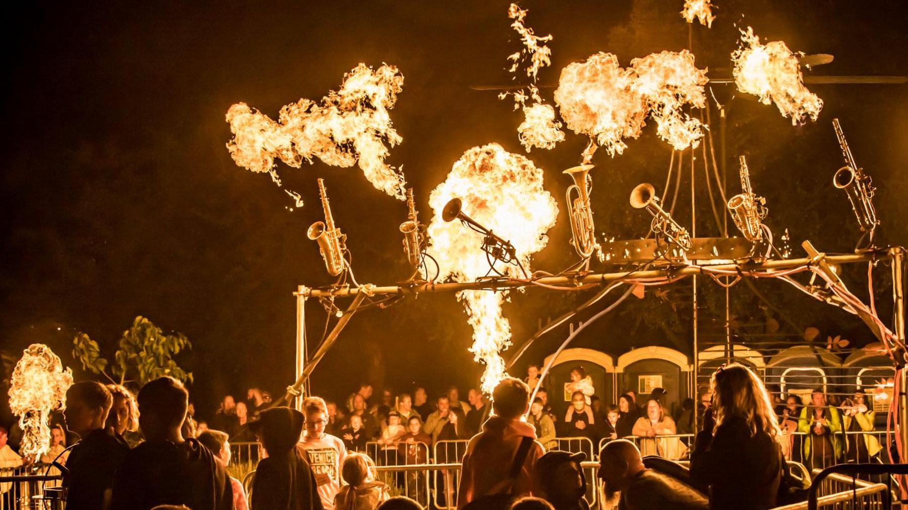 A fire show surrounded by a crowd