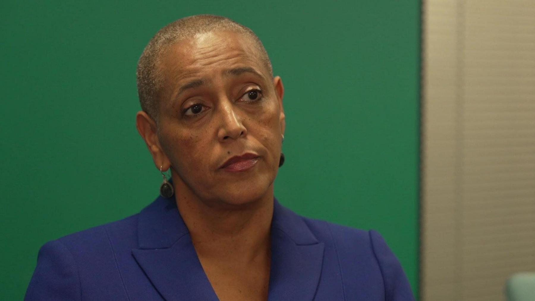 West Yorkshire deputy mayor Alison Lowe, pictured against the backdrop of a green wall. She is wearing a navy suit jacket.