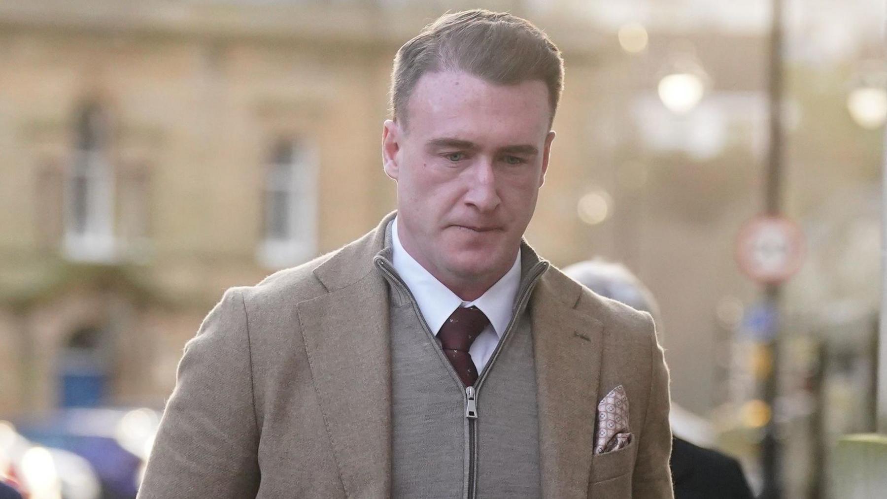 Former Scotland rugby captain Stuart Hogg in a grey zip-up top with a jacket over the top and a purple tie on a white shirt
