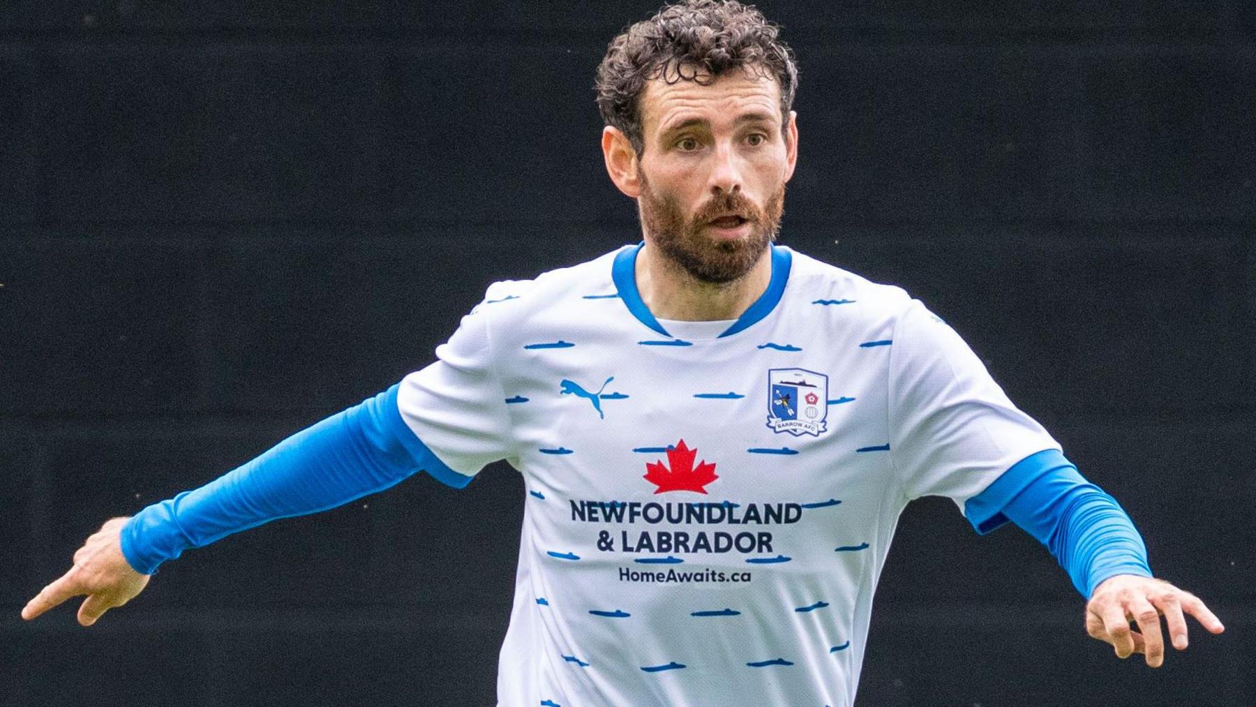 Barrow player David Worrall wearing Barrow's kit with Newfoundland and Labrador written on it