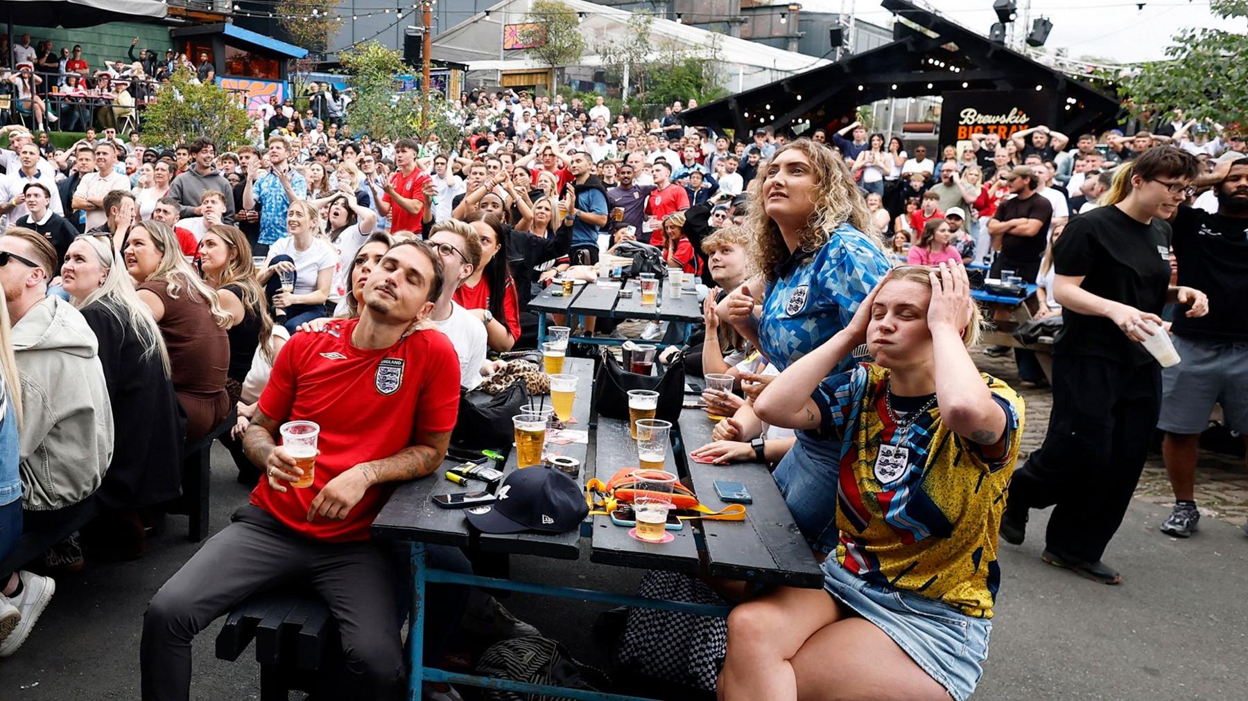 Fans watch England play DR Congo in a Manchester pub garden on Wednesday