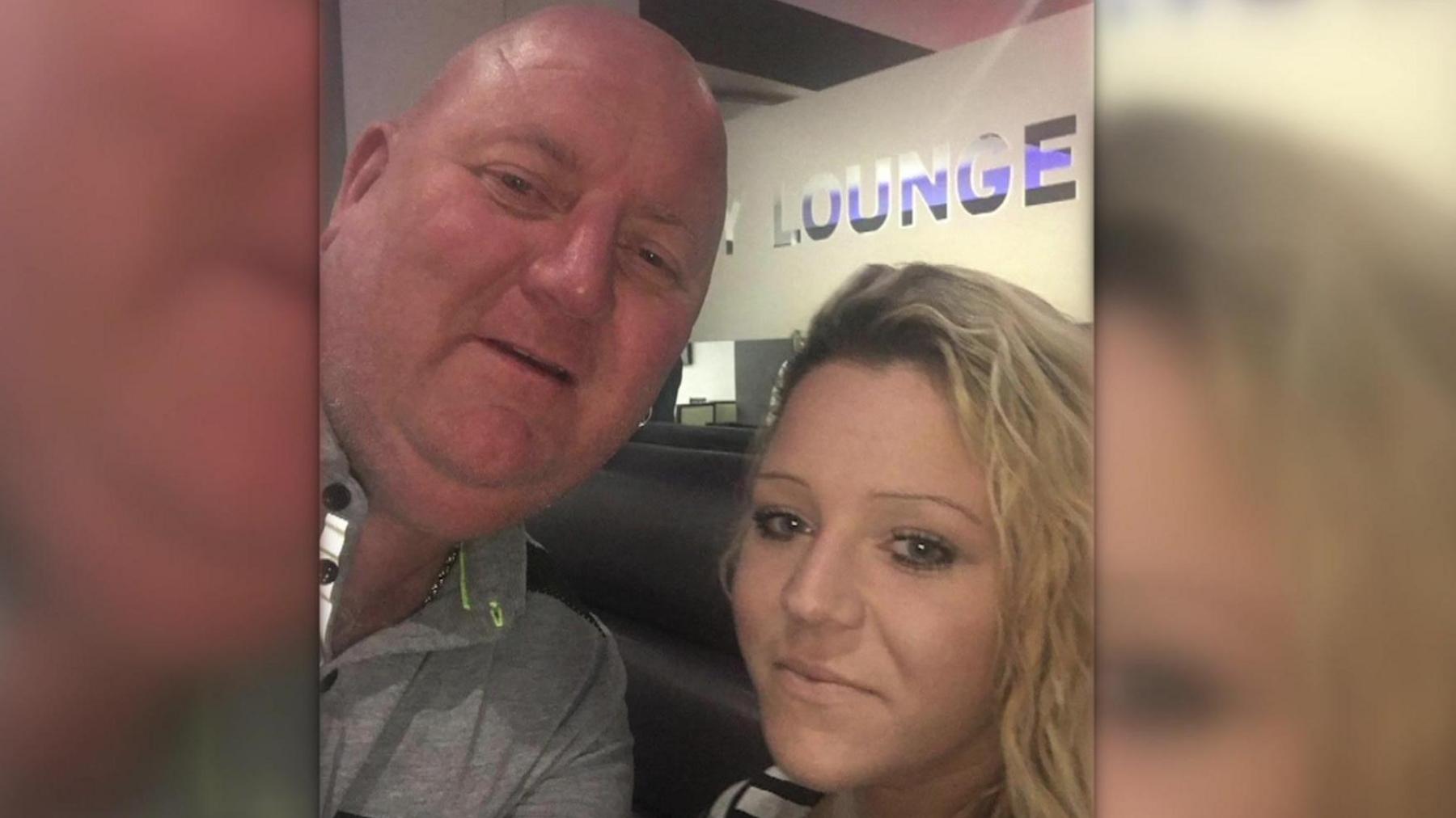 Paul 'Tango' Gregory and his daughter, Lauren Walker, side-by-side. The photo is a selfie, apparently taken in a departure lounge, and they are both looking into the camera. 