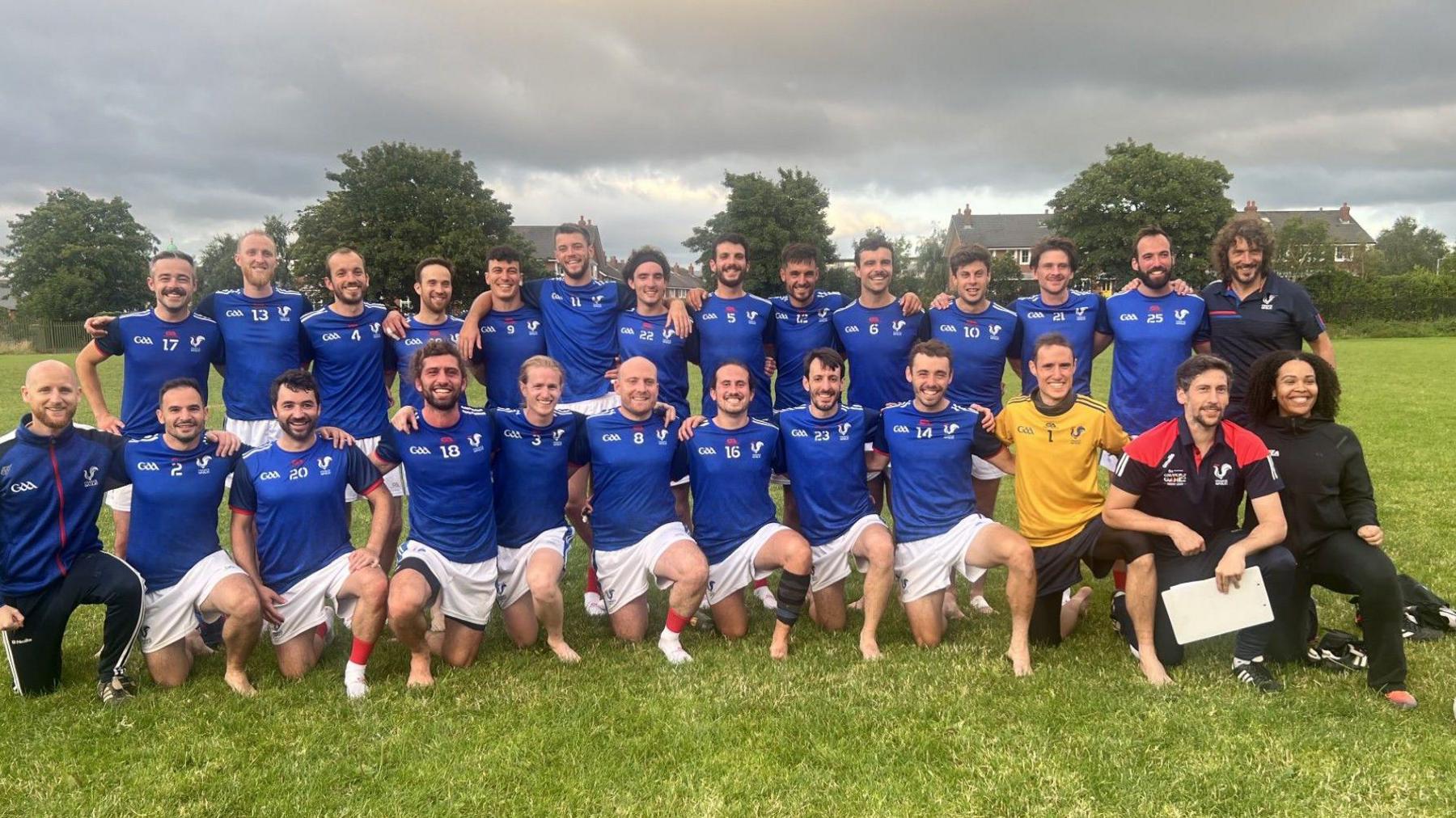 Members of French Gaelic football team on GAA pitch wearing blue. 