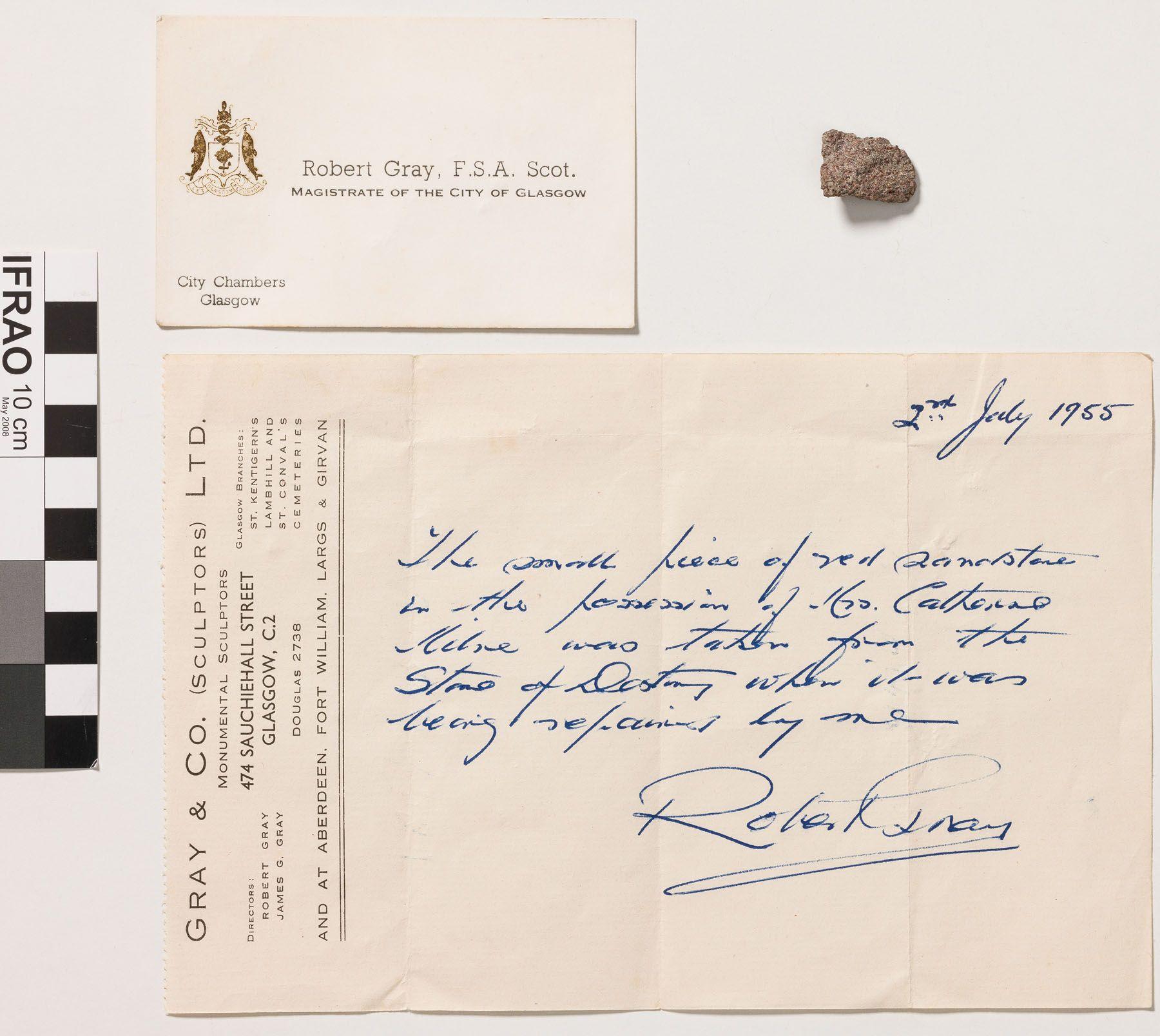 A small piece of stone, the business card of Robert Gray and a certificate of authenticity from Robert Gray
