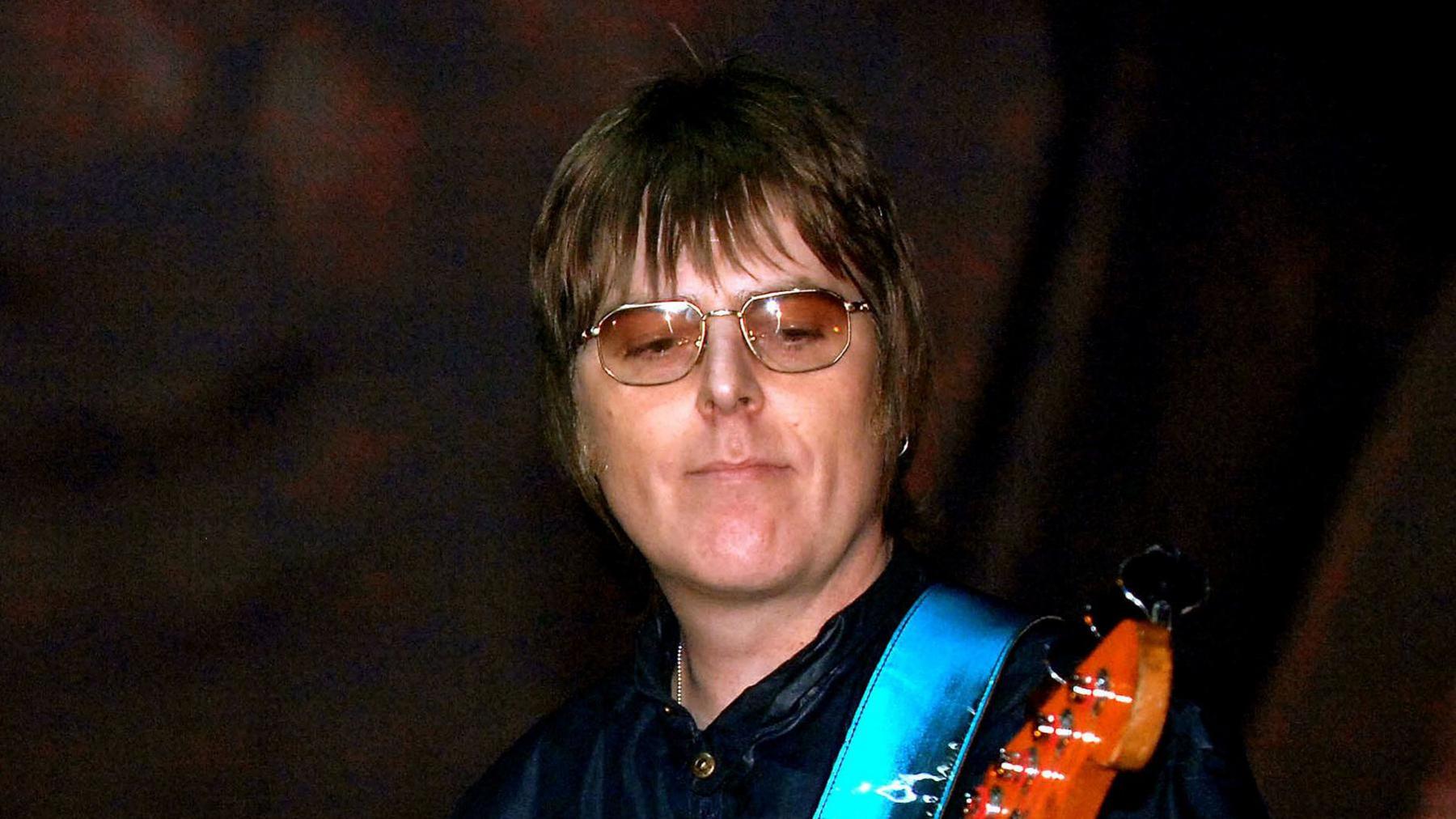 Andy Rourke playing guitar on stage in 2006