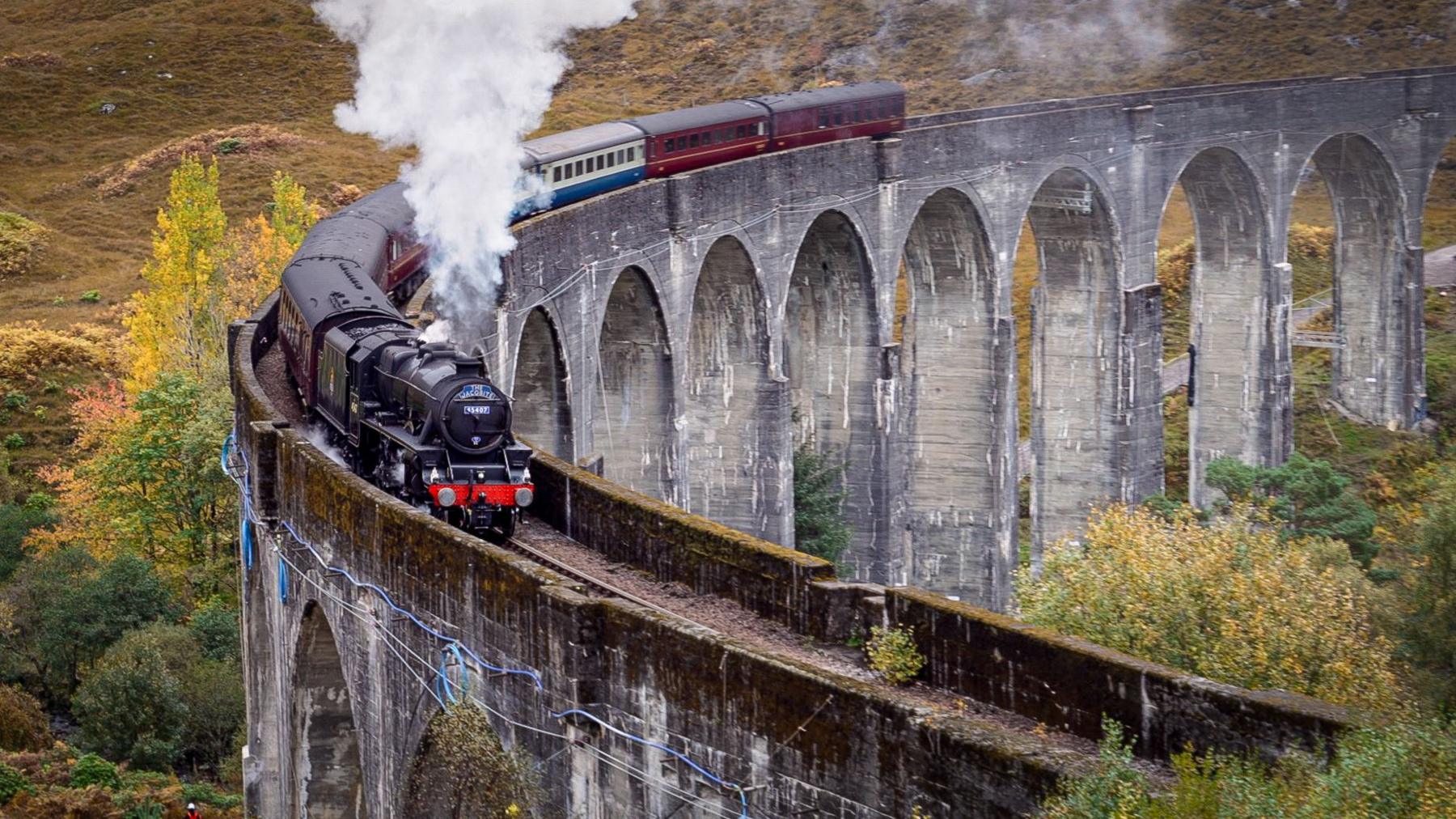 The Glenfinnan Viaduct and the Hogwarts Express (Jacobite steam train) in the Scottish Highlands, made famous by the Harry Potter series of films. October 2024.