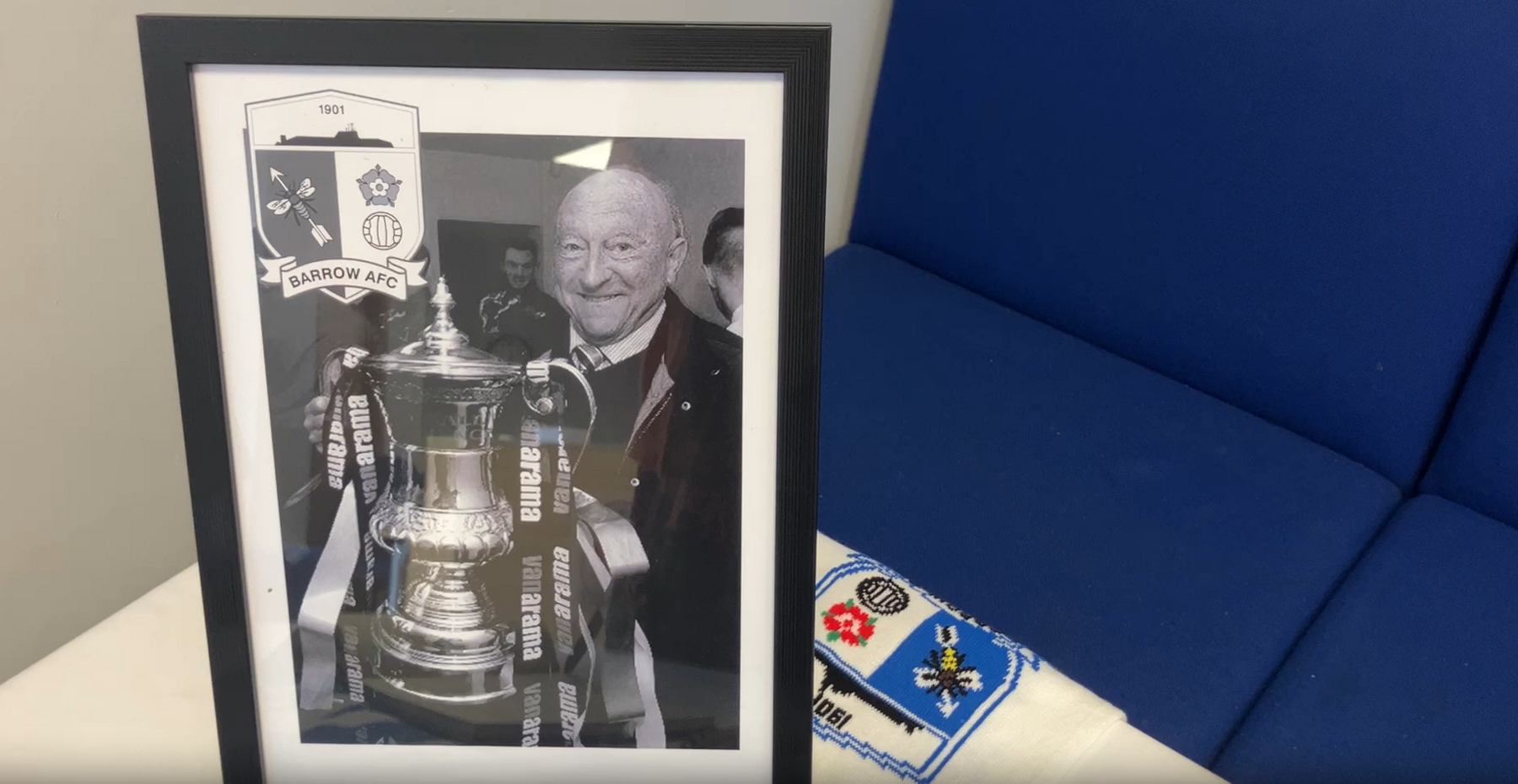 A picture frame of Brian Keen smiling with a trophy.