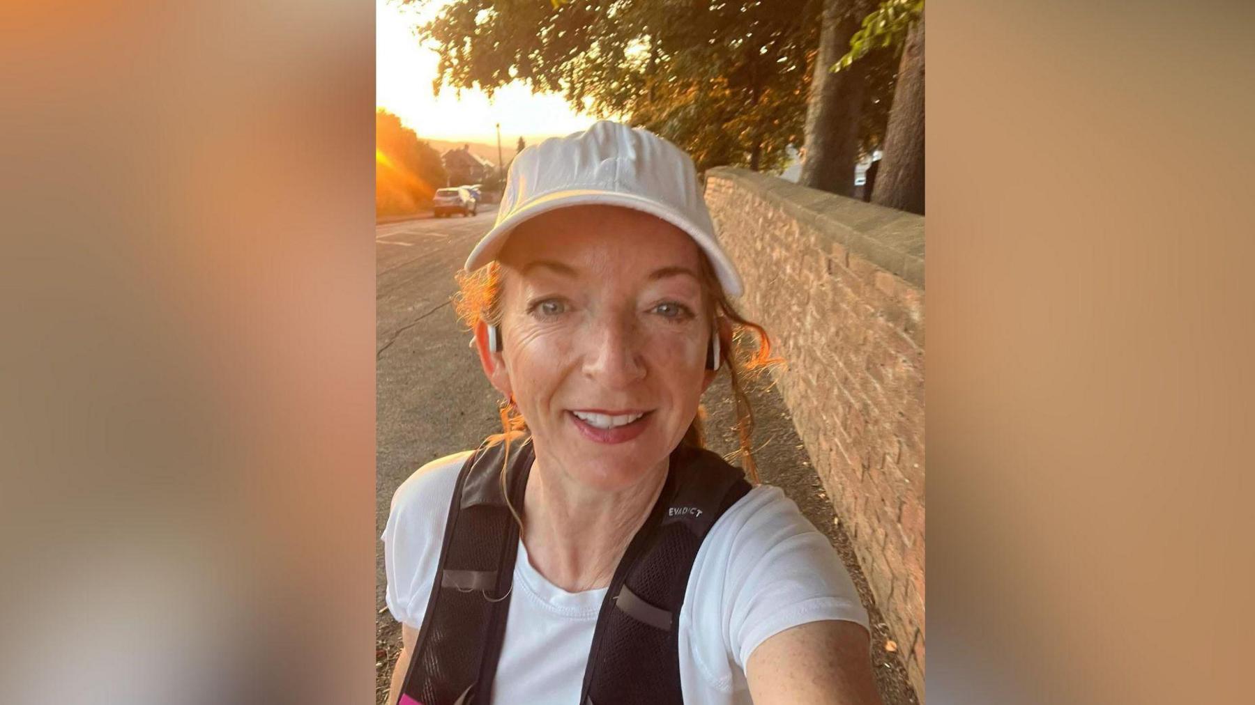 Sarah-Jane Hill with earphones in and a white cap on