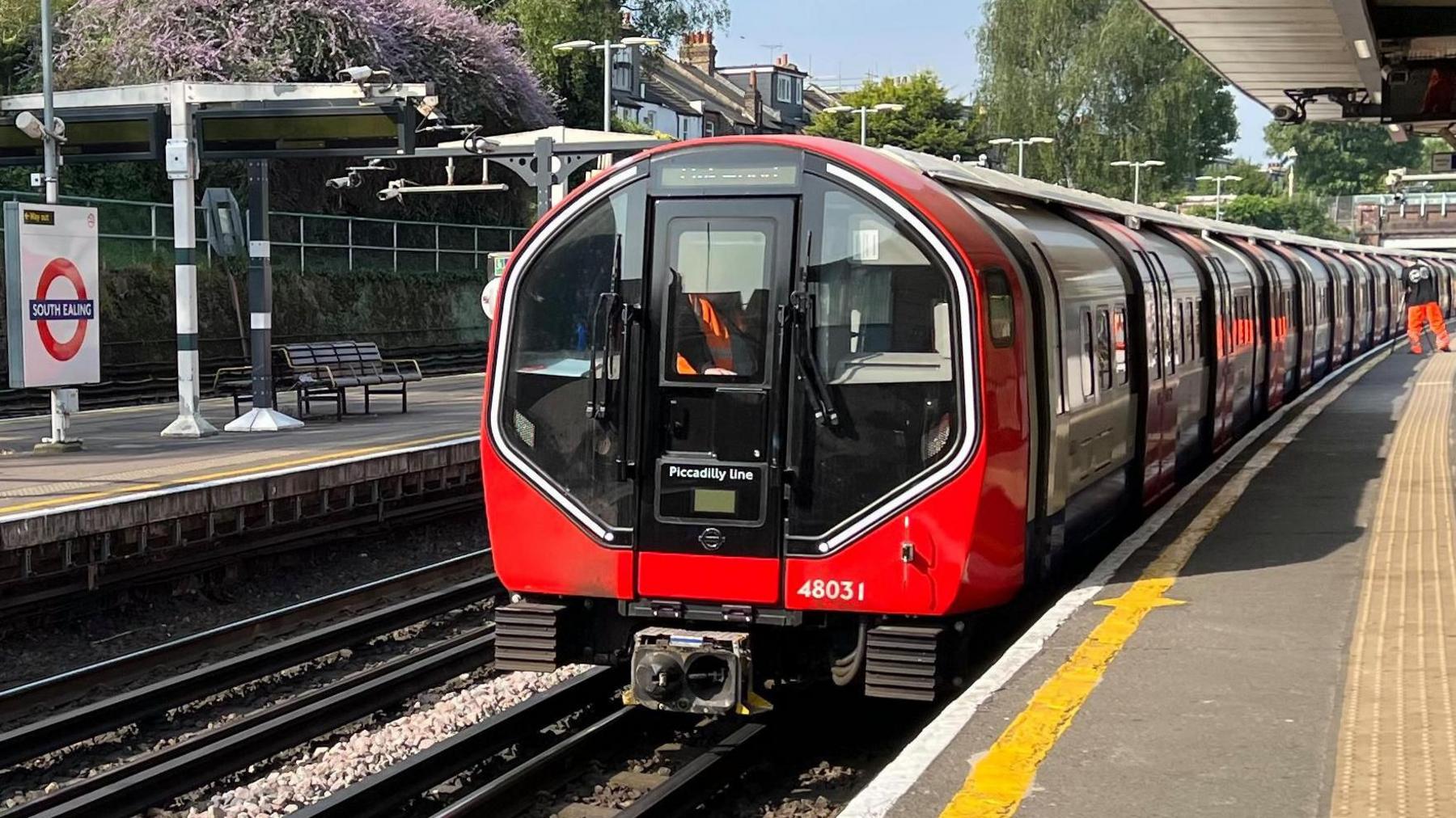 A Tube train with a halo light around the cab is in a station
