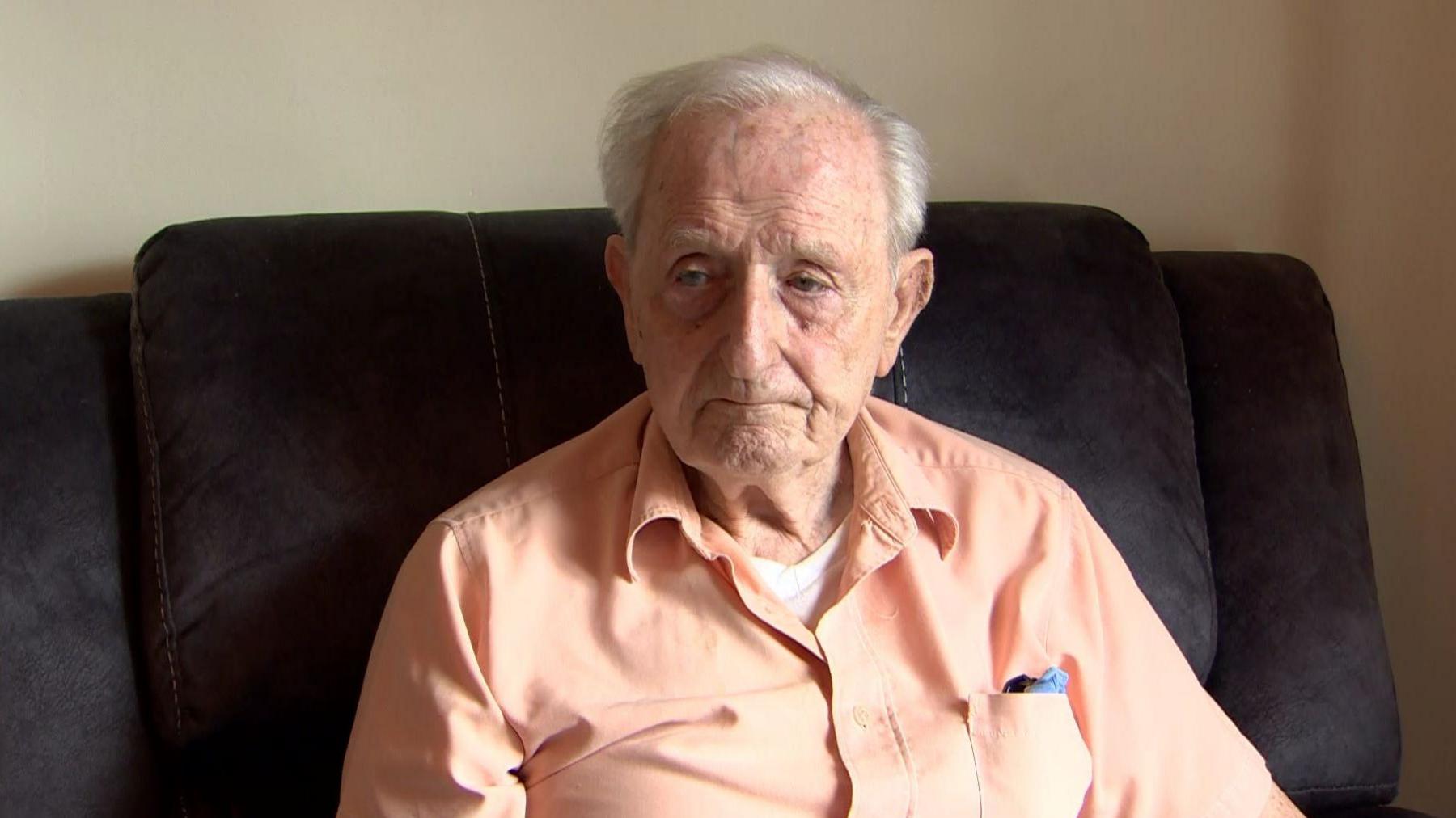 91-year-old resident Eamon Melaugh sitting in an armchair as he speaks to BBC News NI