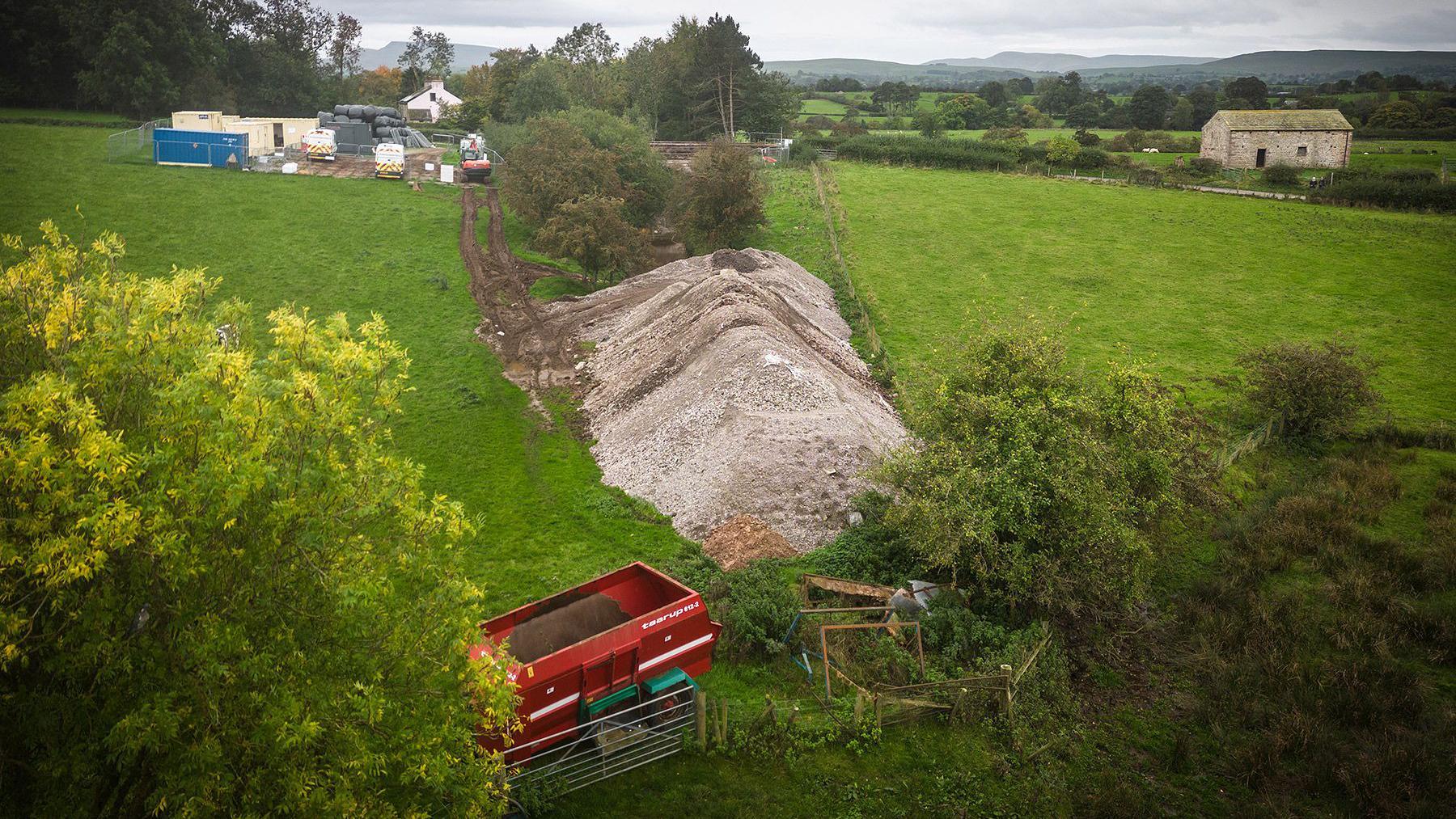 Concrete infill removed from under Great Musgrave Bridge piled up on adjacent land