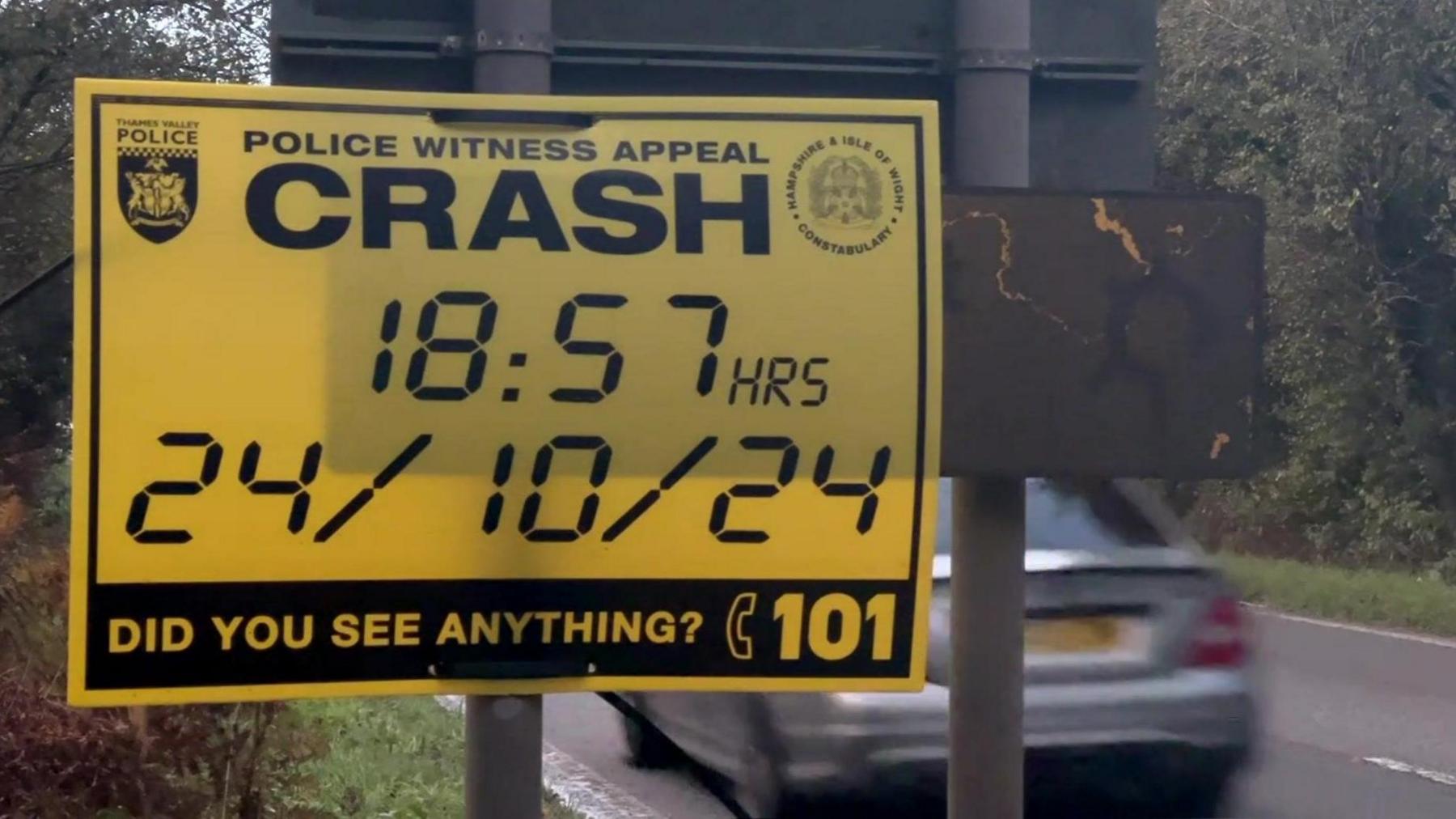 A yellow police witness appeal sign alongside the road, it says 'Crash - 18:57 hrs 24/10/24 Did you see anything?'