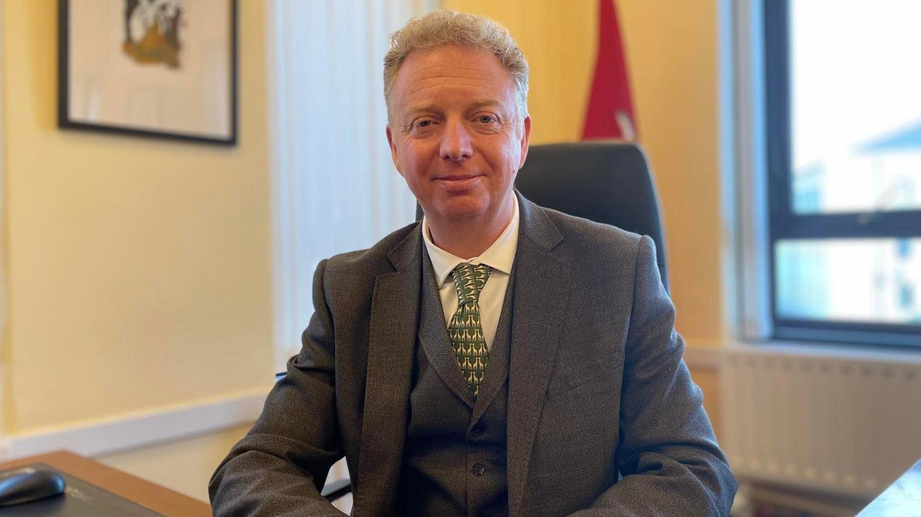 Alex Allinson sitting at a desk