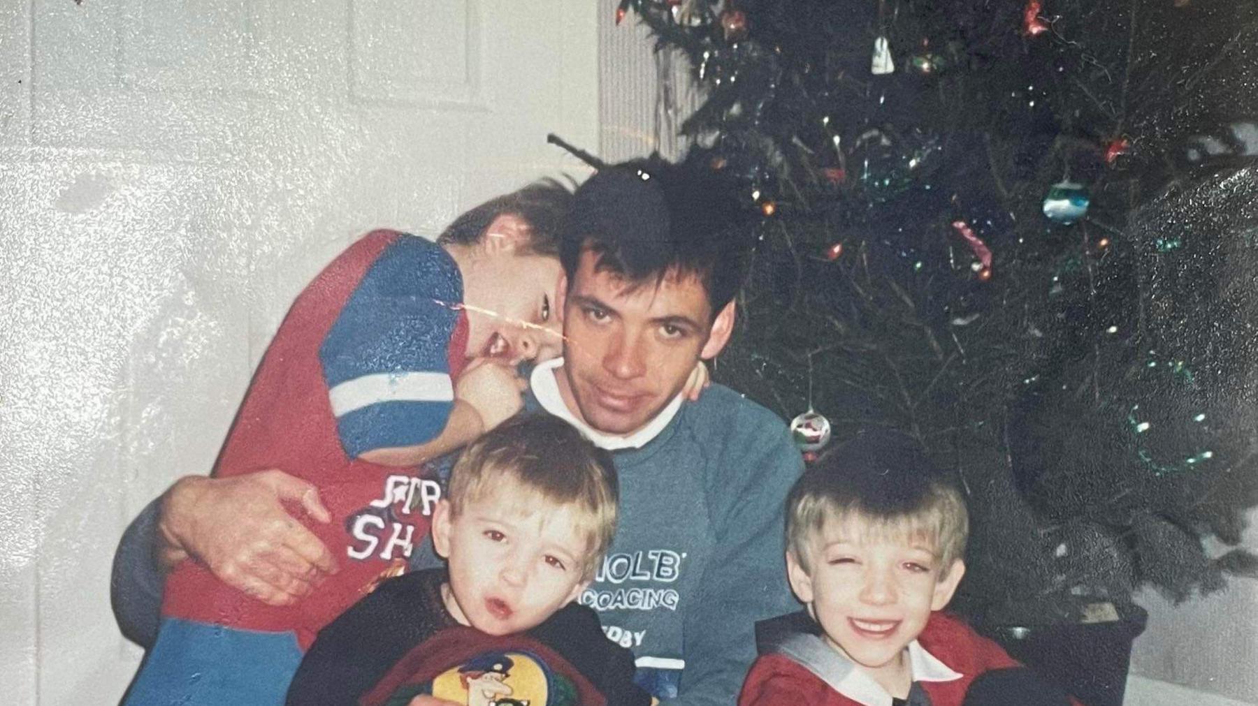 Ben and his family in front of the Christmas Tree