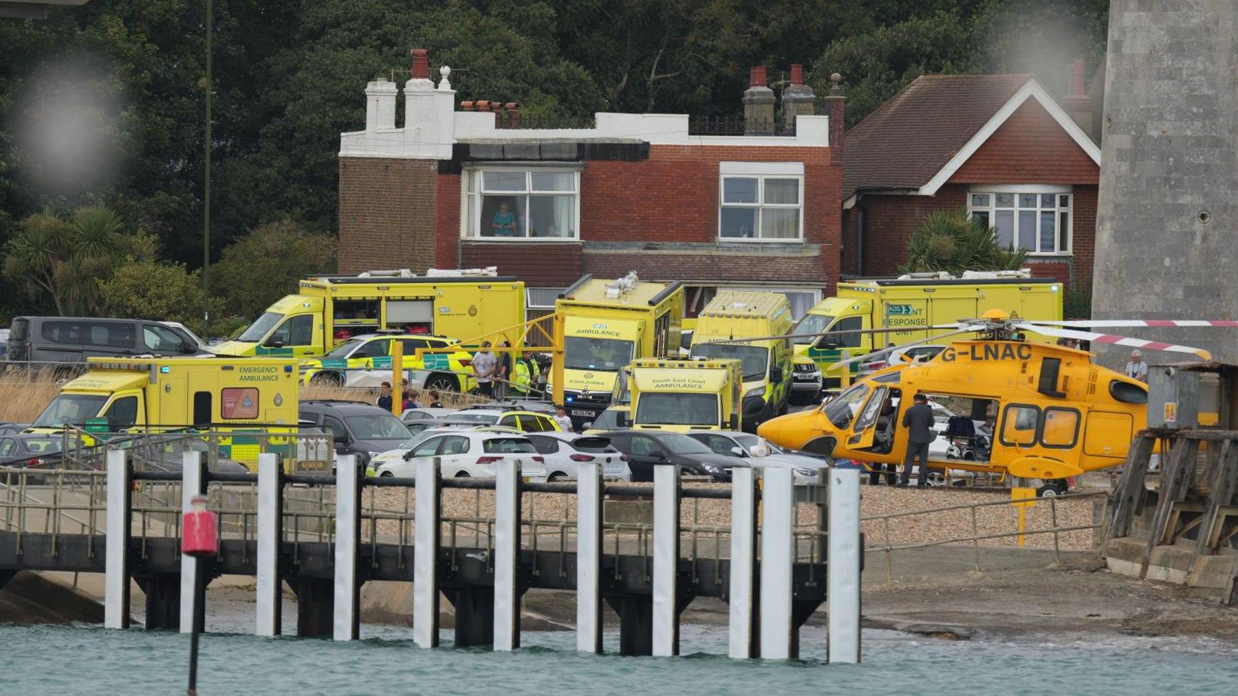 Numerous ambulances and a coastguard helicopter at the scene on the water's edge