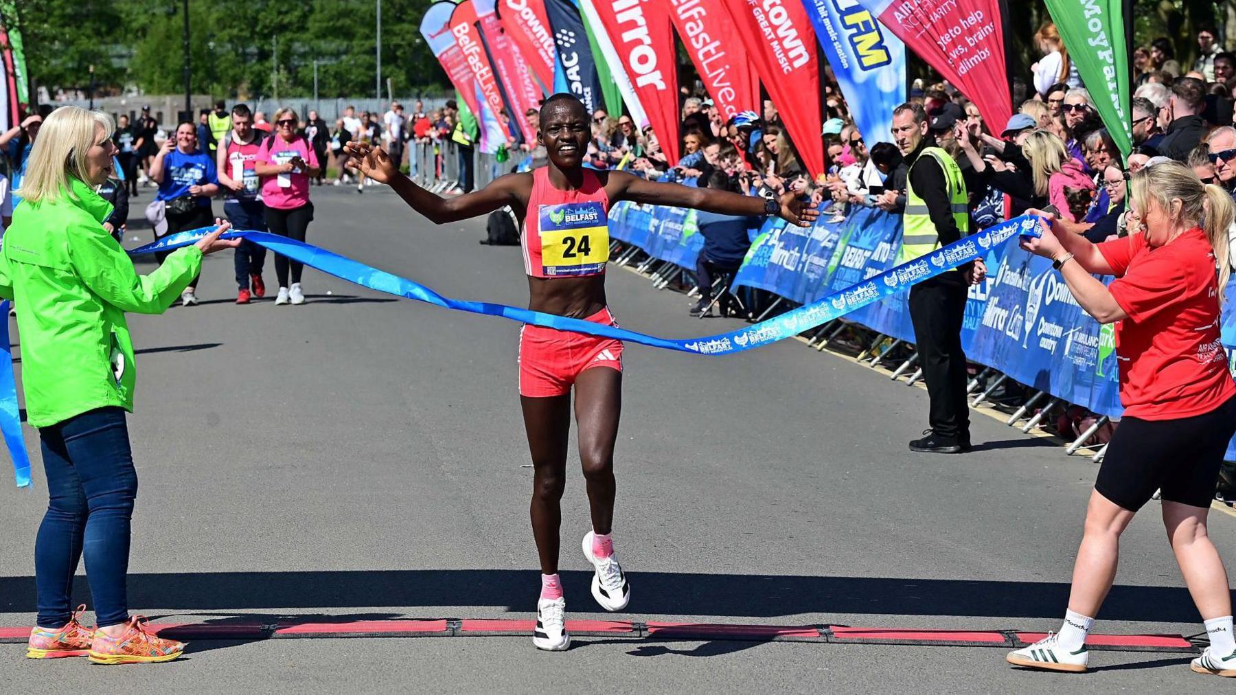 Kenya's Millicent Kibet crosses the line to win the women's race at the Belfast Marathon