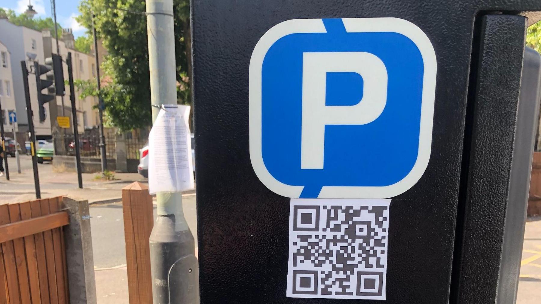 Parking ticket machine with QR code close to road