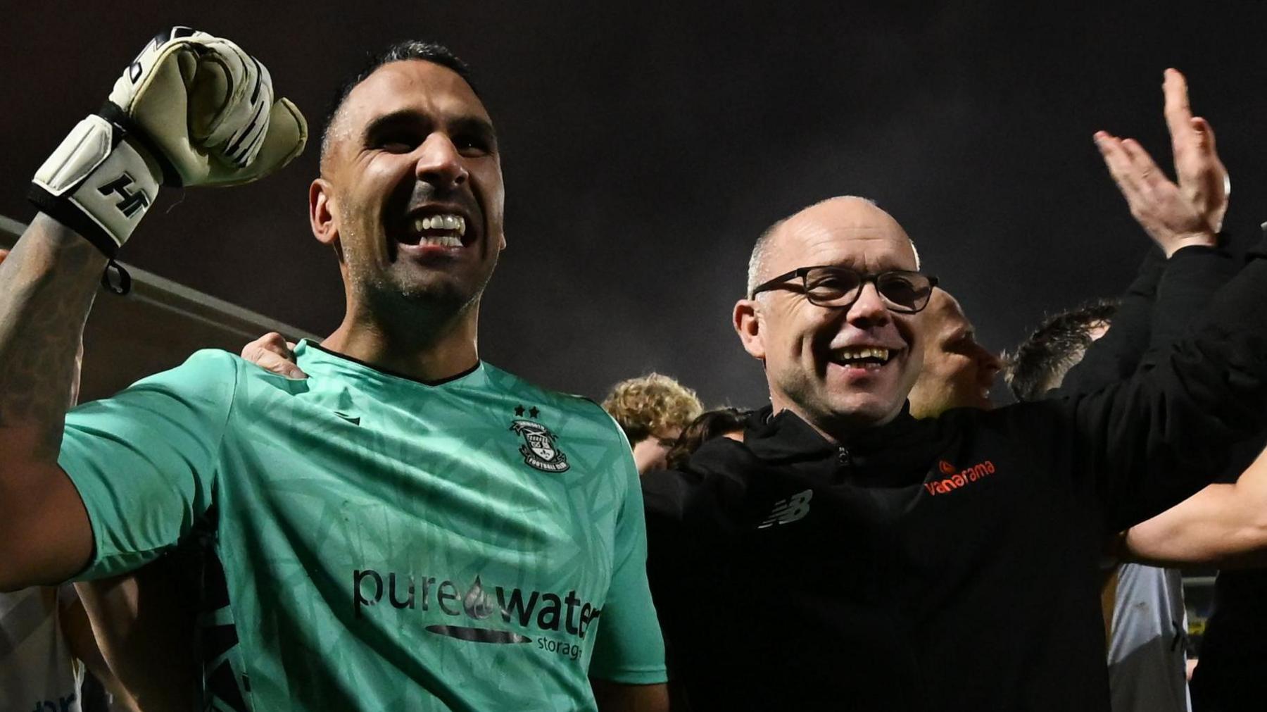 Tamworth boss Andy Peaks (right) celebrates with keeper Jas Singh after the penalty shootout win over Burton Albion at the Pirelli Stadium