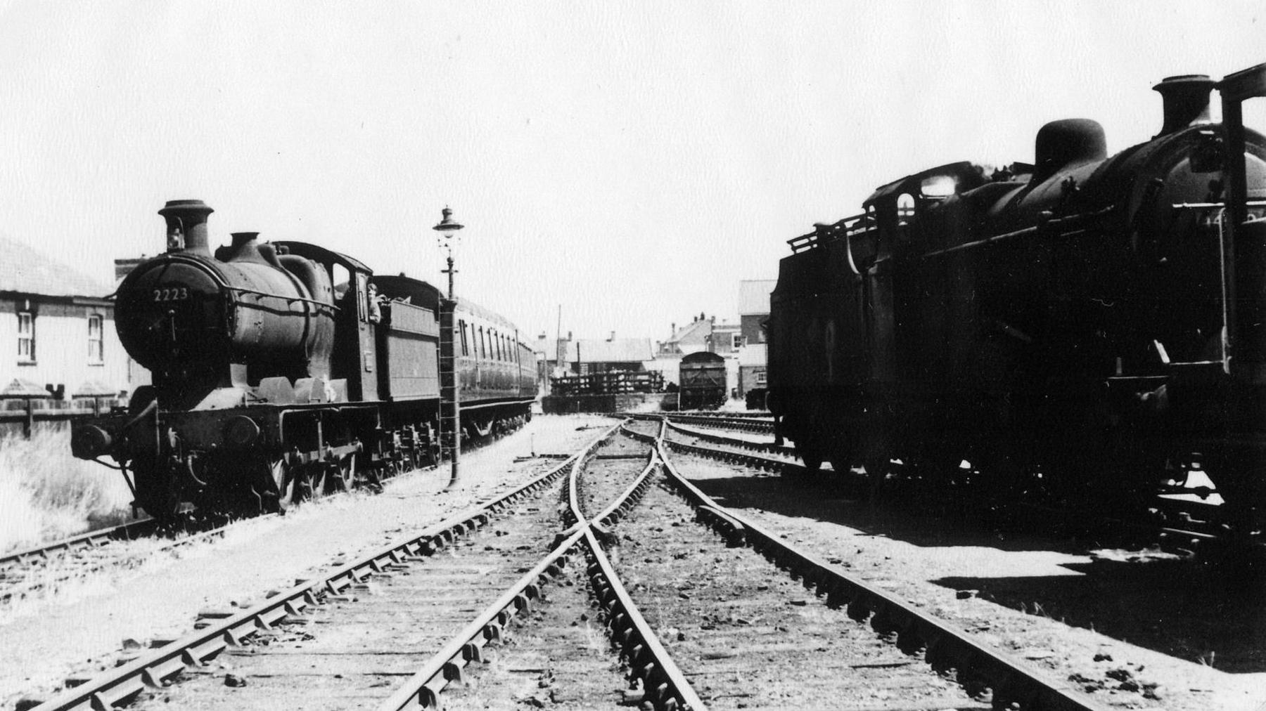 A black and white photo of two steam trains.