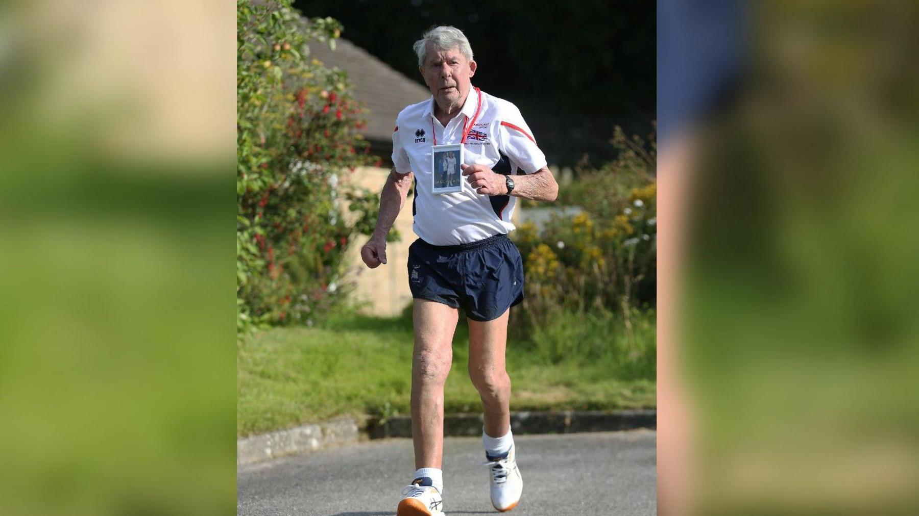 Mike Gibbons wearing blue shorts and a white tshirt running 