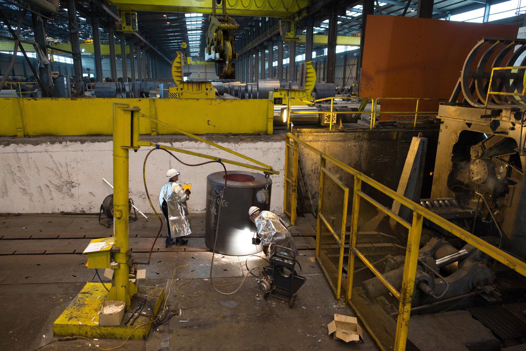 Workers looking at a roll of steel in Liberty Steel Newport