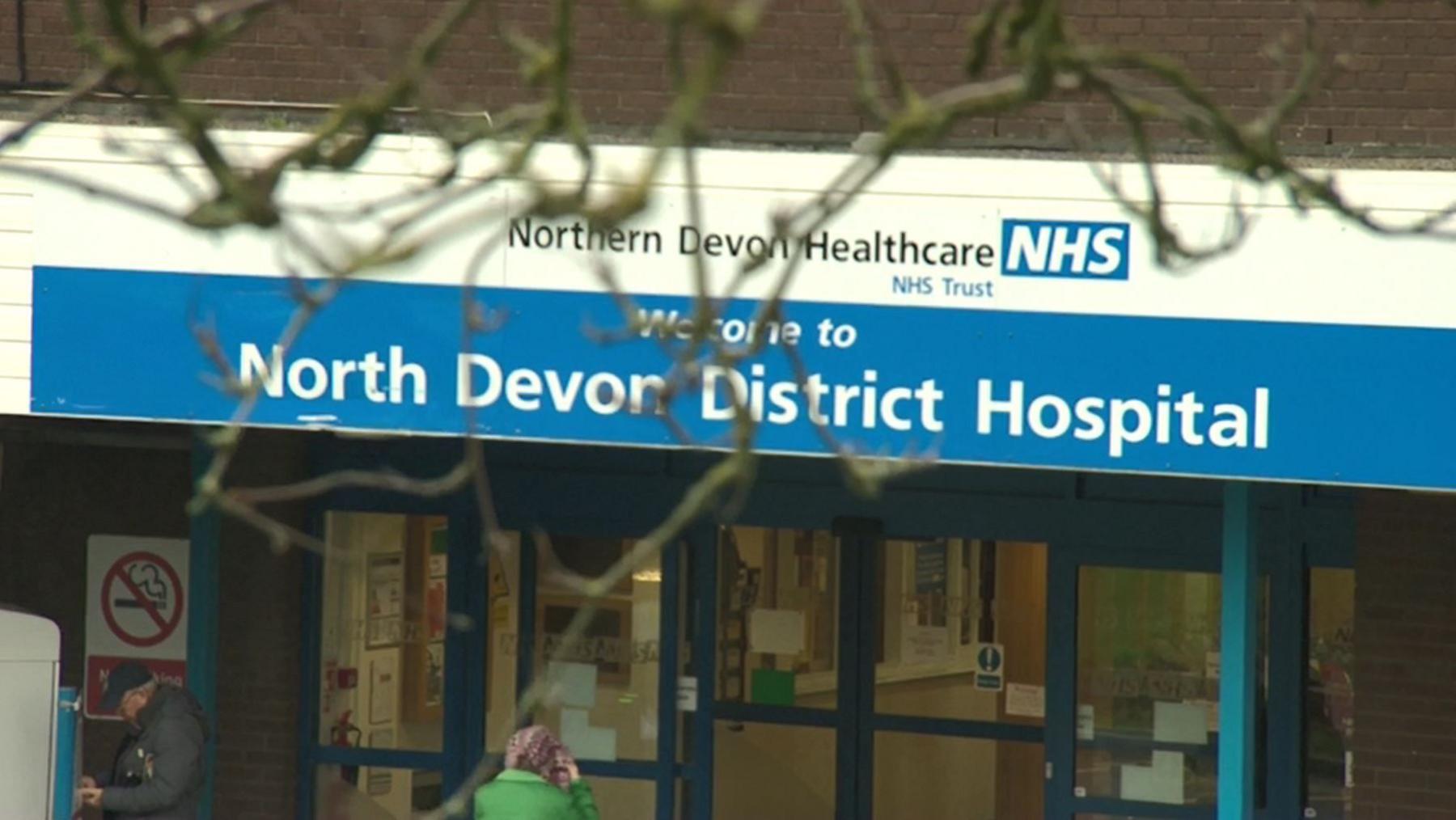 The glass door-fronted North Devon District Hospital, with a welcome sign above it