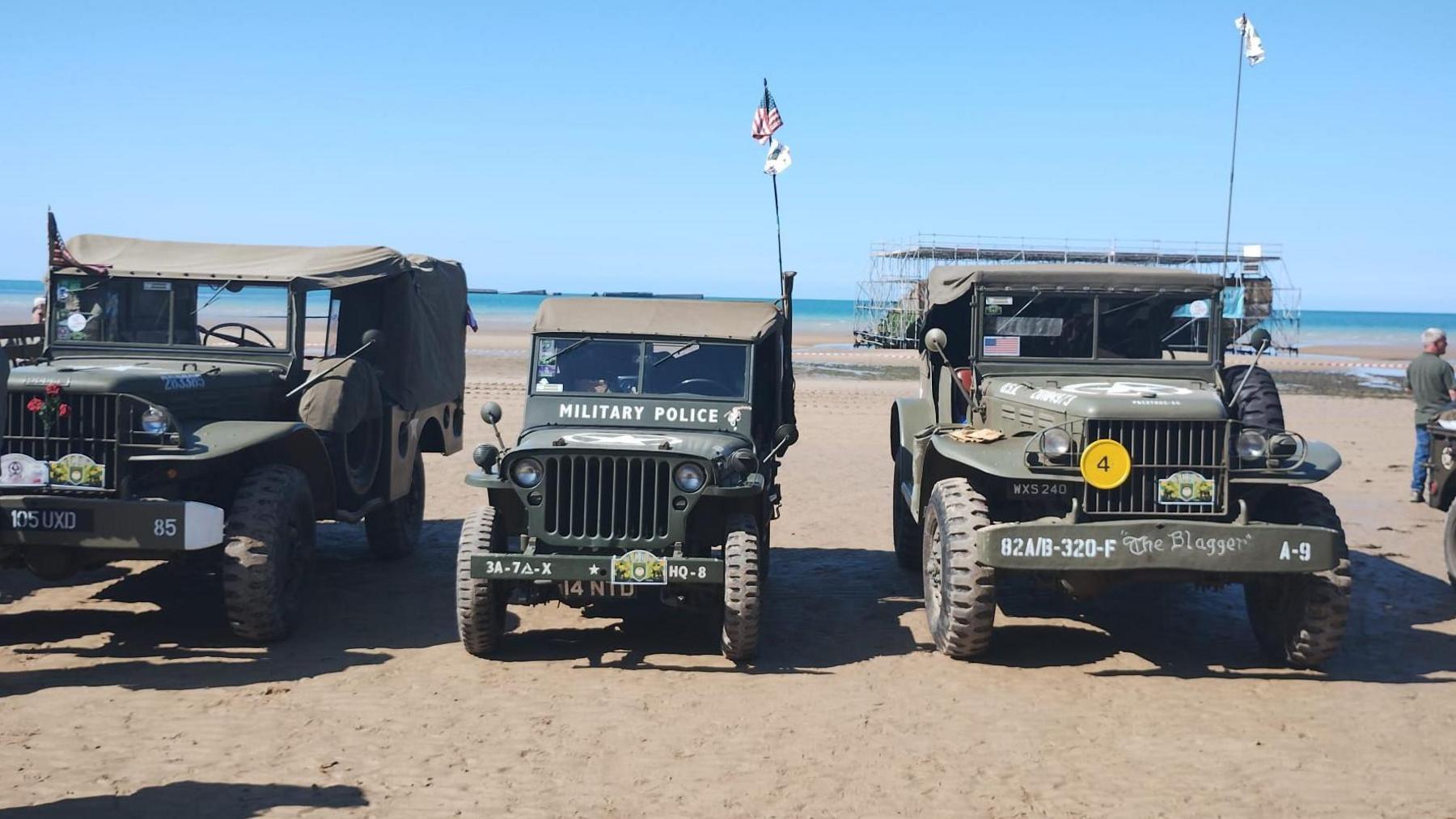 Three WW2 vehicles on a beach in Normandy