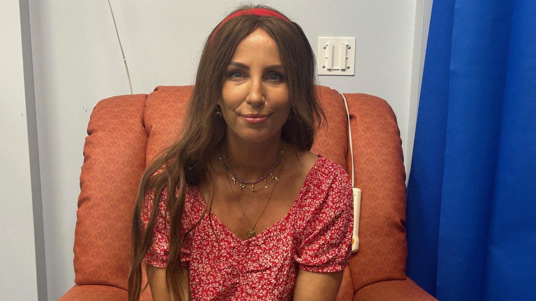 A woman in a red dress with long brown hair and a red head band