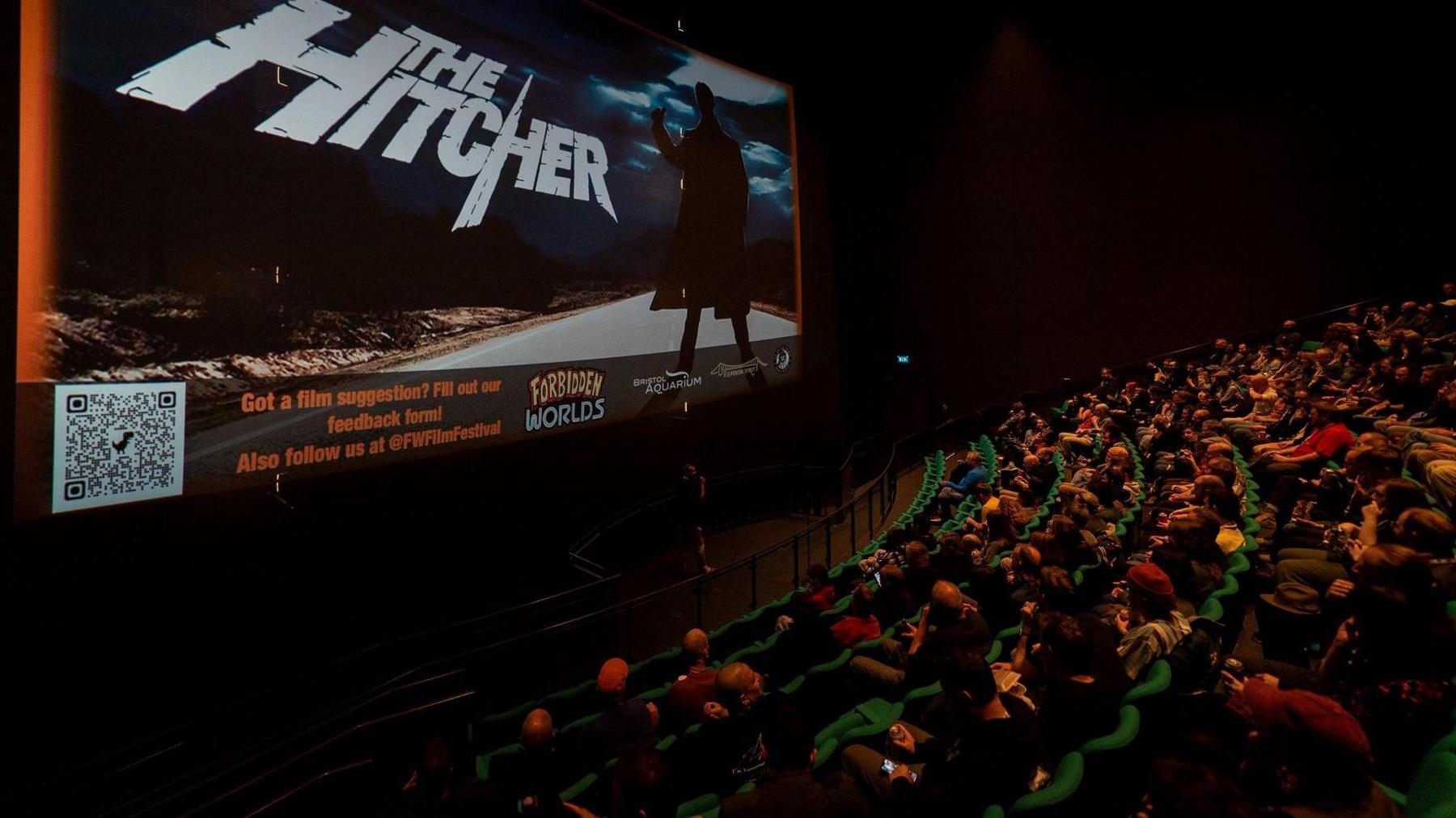 People sit in their seats at the iMax cinema in Bristol to watch The Hitcher as part of a series of horror film screenings as part of the Forbidden Worlds festival. On the screen the opening credits for The Hitcher are visible