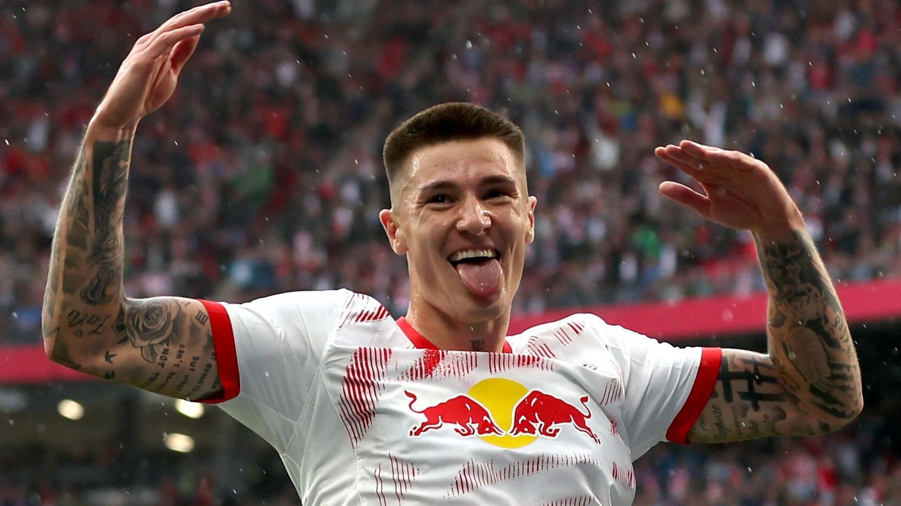 Benjamin Sesko raises his arms in celebration after scoring for RB Leipzig
