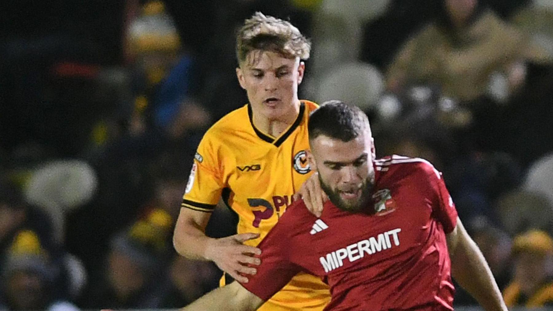 Tom Davies of Newport County is challenged by Aaron Drinan of Swindon Town