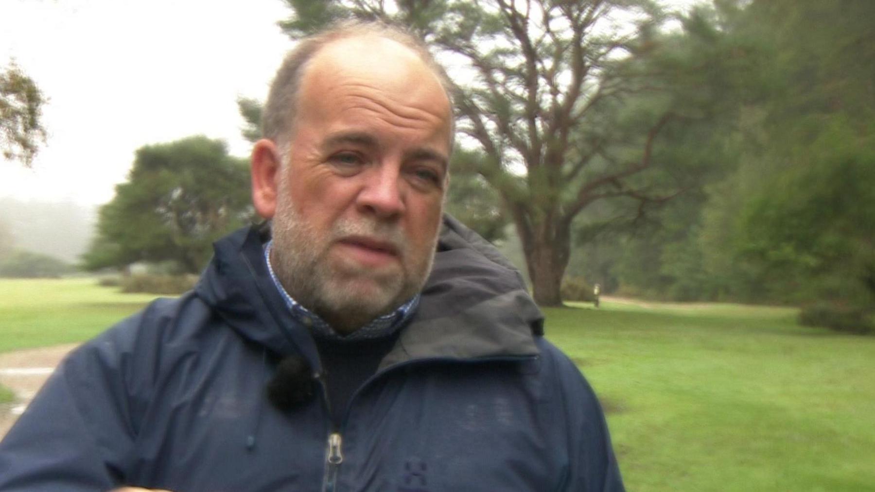 Craig Harrison of Forestry England in a blue anorak, standing in front of trees in the New Forest