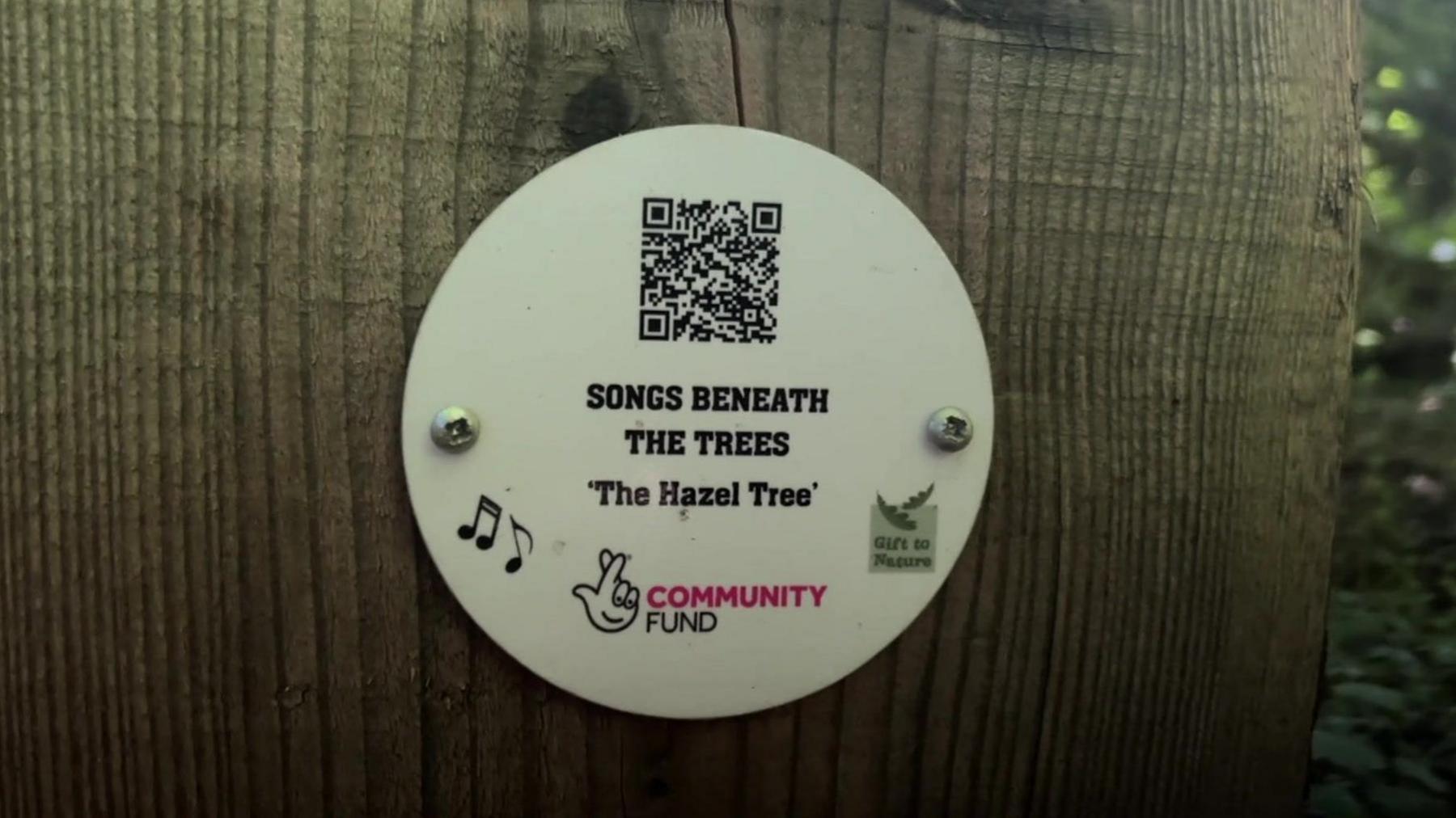 QR code attached to a wooden marker post