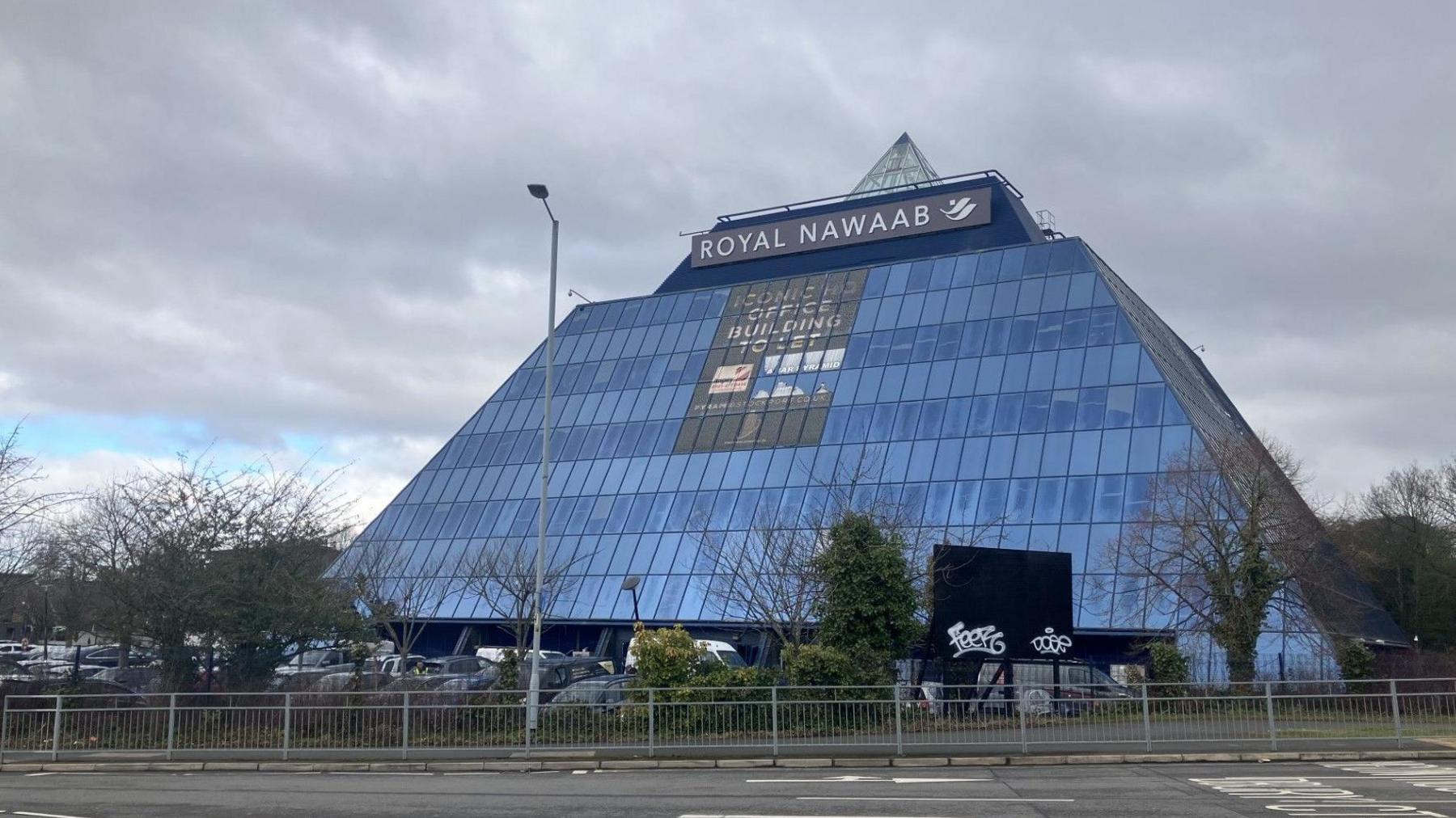 A wide shot of the Stockport Pyramid. It is a pyramid shape covered in windows.