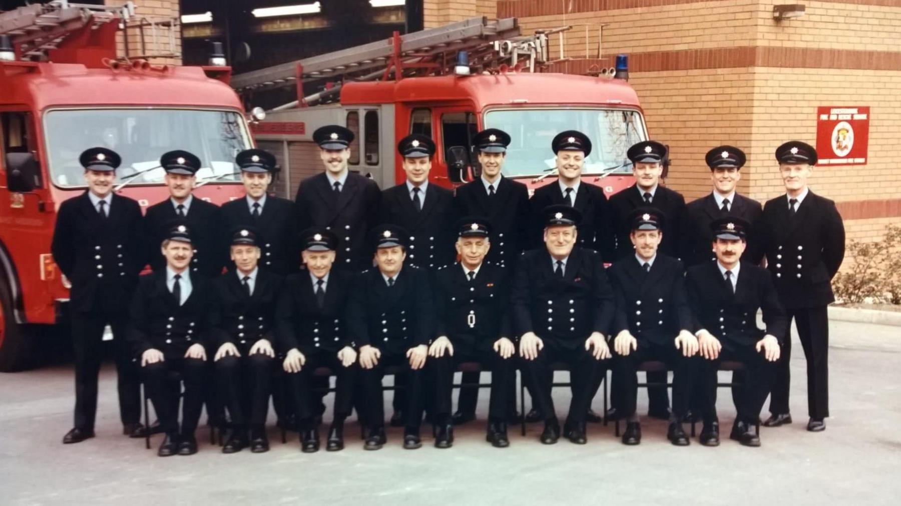 A group photo of uniformed firefighters in front of the Market Harborough fire station