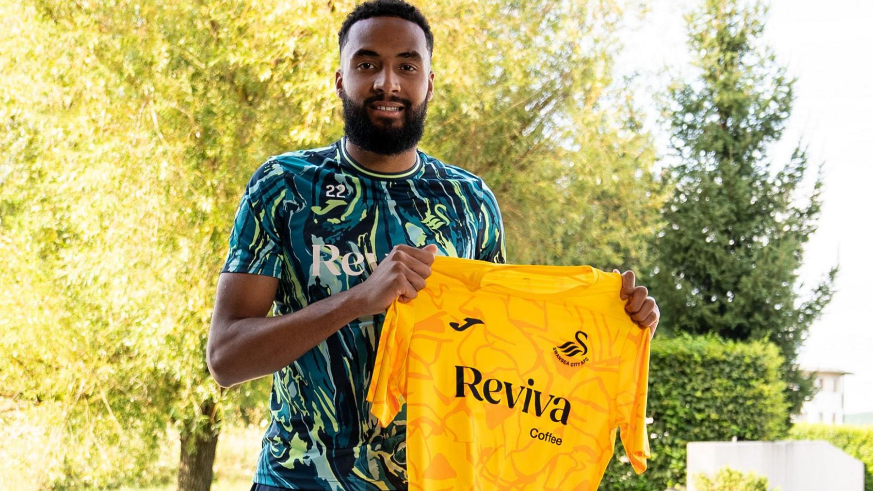 Lawrence Vigouroux holds up the Swansea goalkeeper's shirt