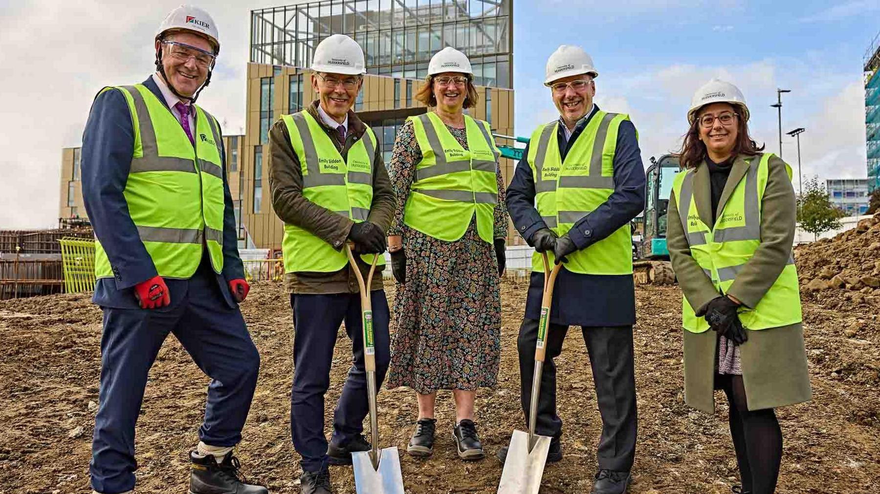 Kier Construction's Daniel Doherty, Professor Tim Thornton, Professor Jane Owen-Lynch, chief executive of Calderdale and Huddersfield NHS Trust Brendan Brown and Huddersfield MP Harpreet Uppal wearing high-vis jackets and holding spades.