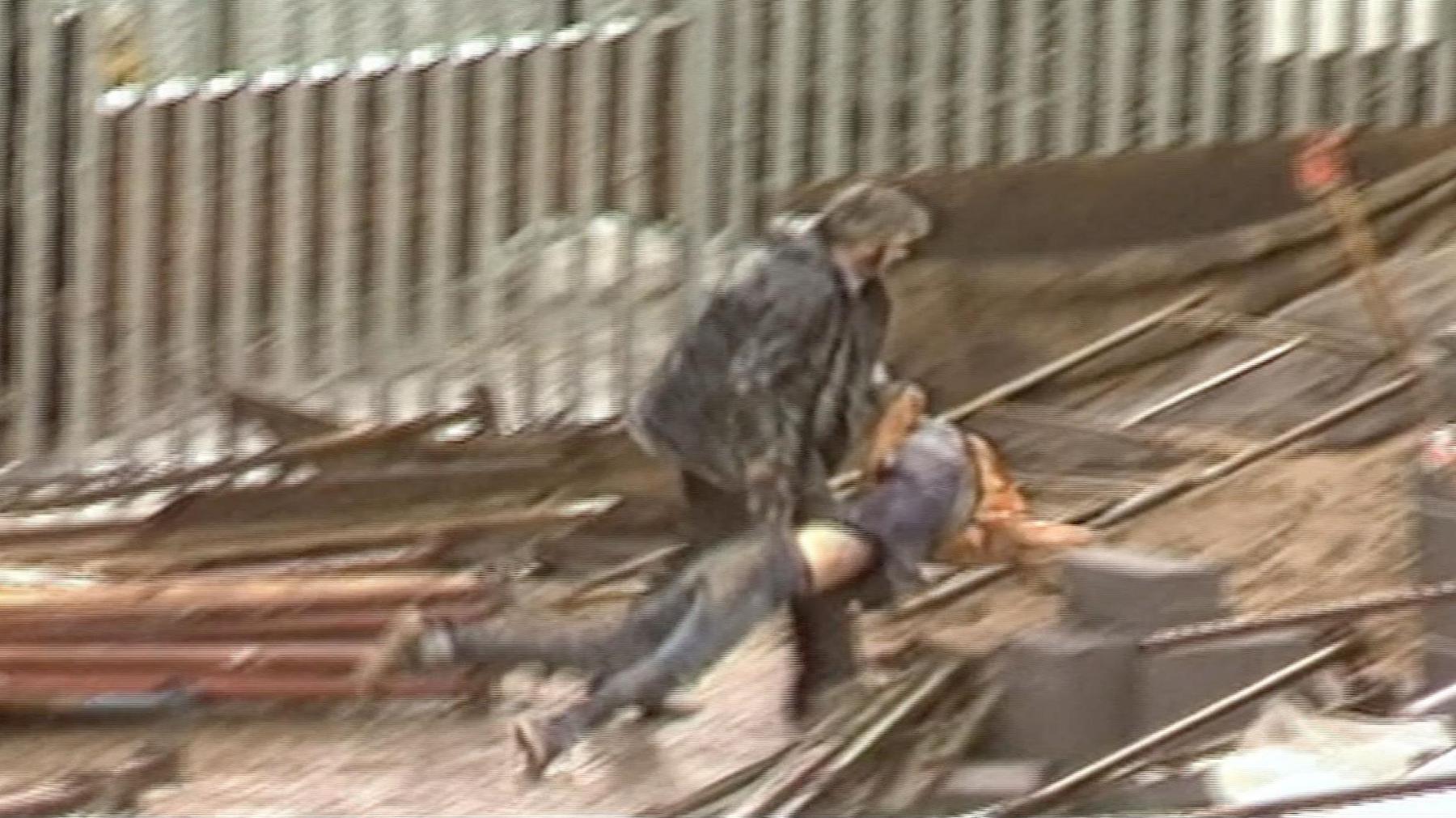 Swyddog diogelwch yn cario protestiwr ar safle adeiladu'r byncer ym 1985