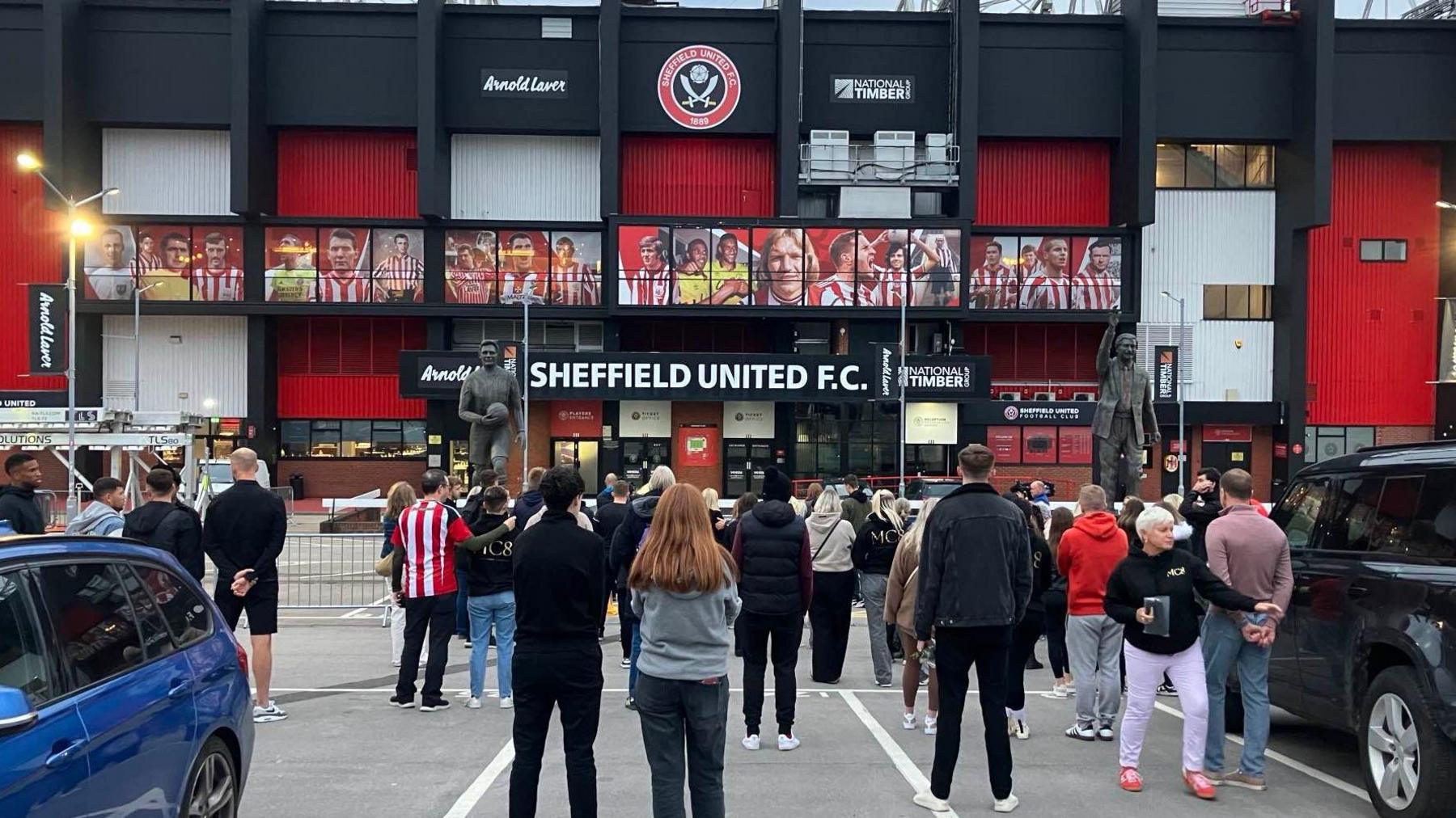 People stand in vigil outside Bramall Lane