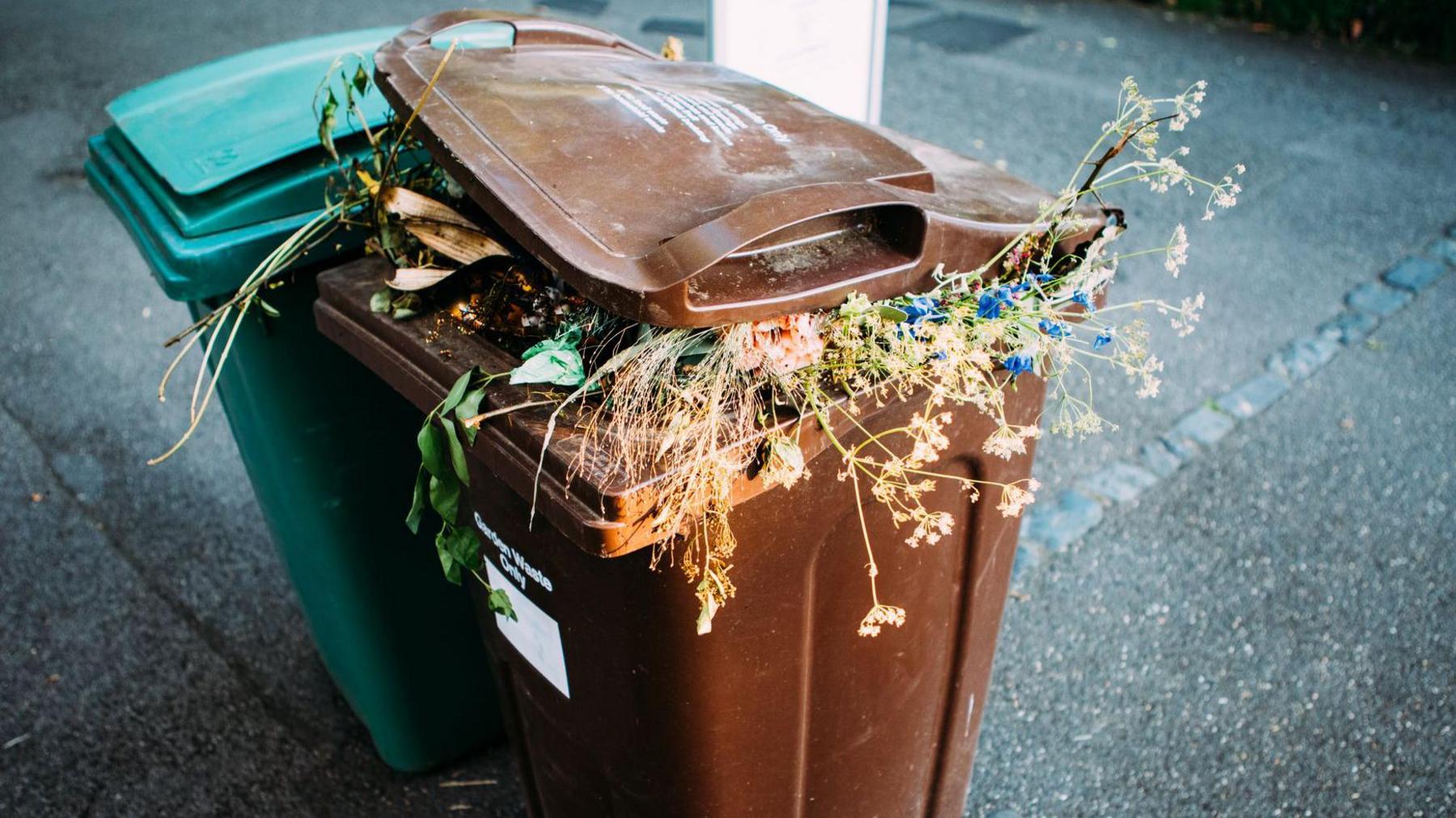 A brown bin overflowing with compostable waste 