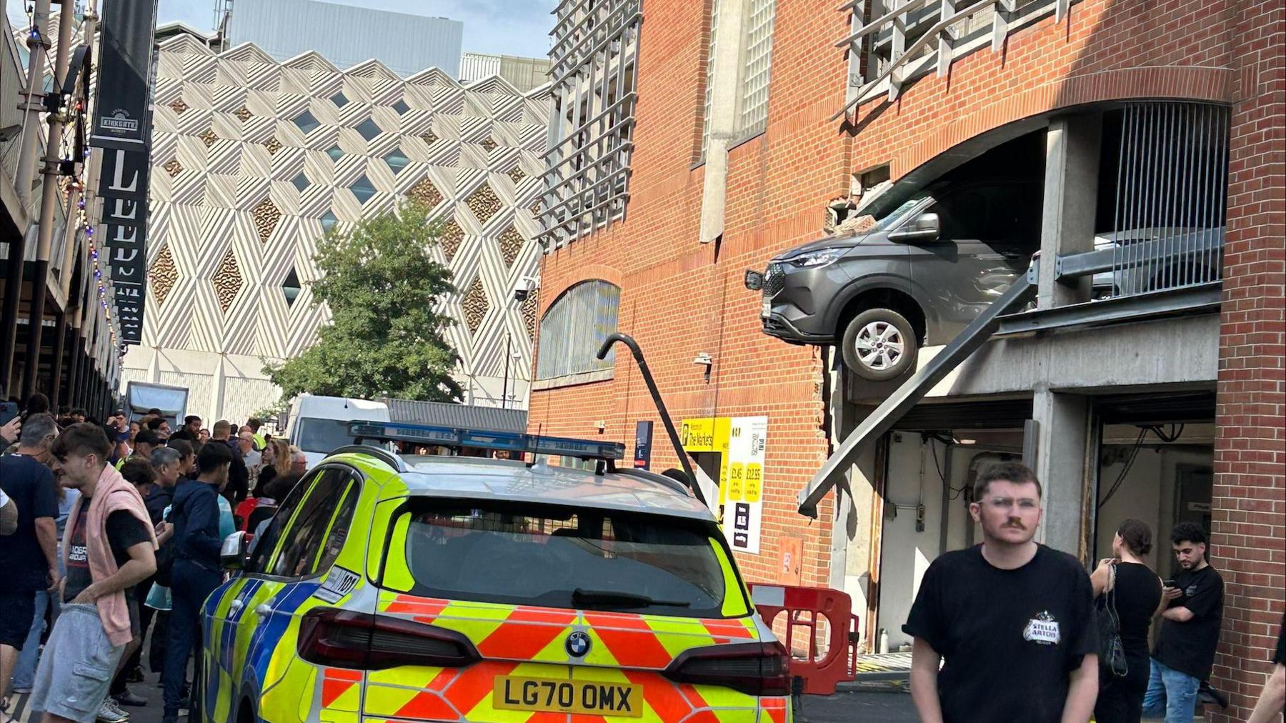A van leaning out of a wall in a multi-storey car park