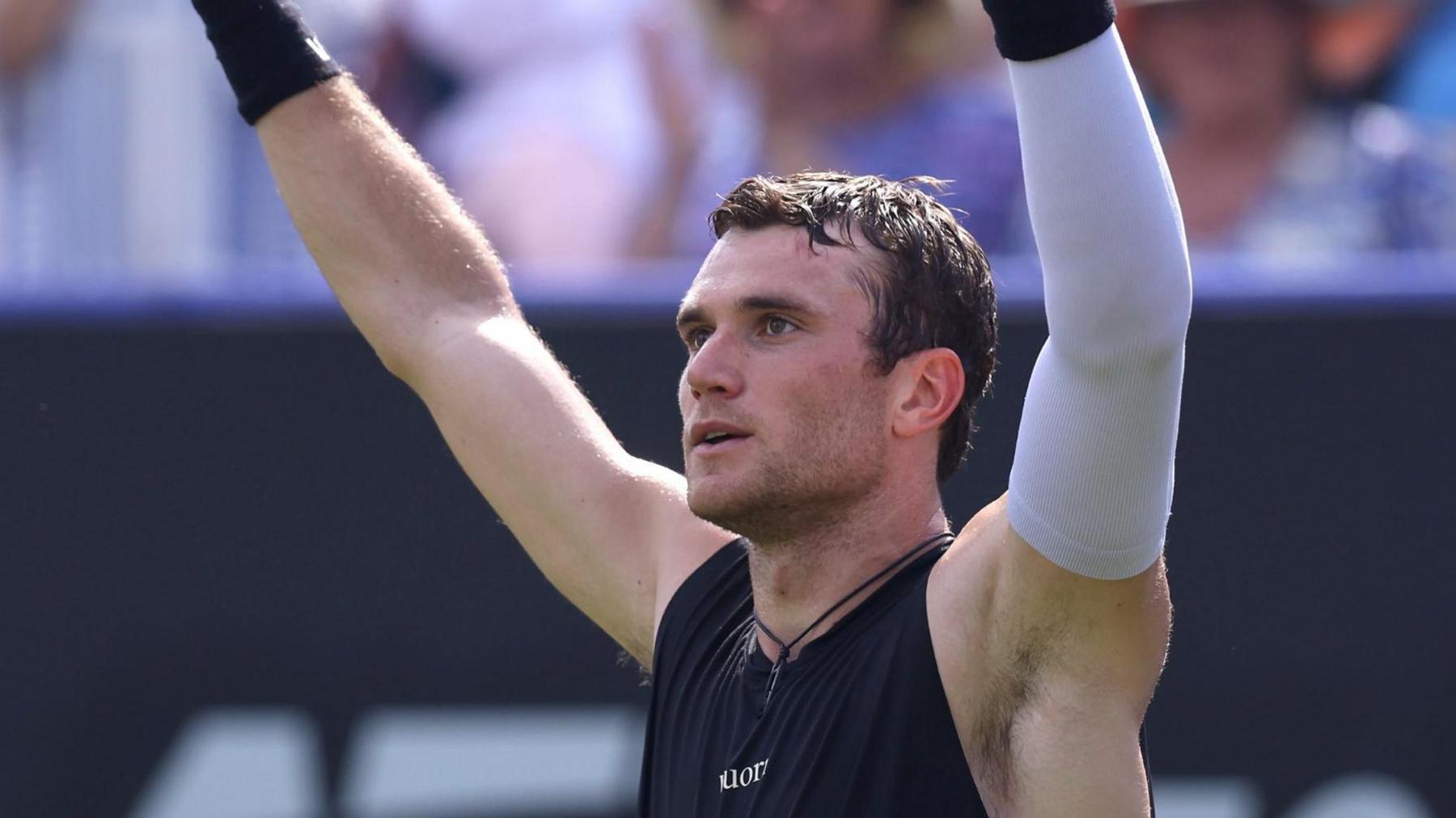 Jack Draper lifts his arms in celebration after winning his quarter-final at Eastbourne